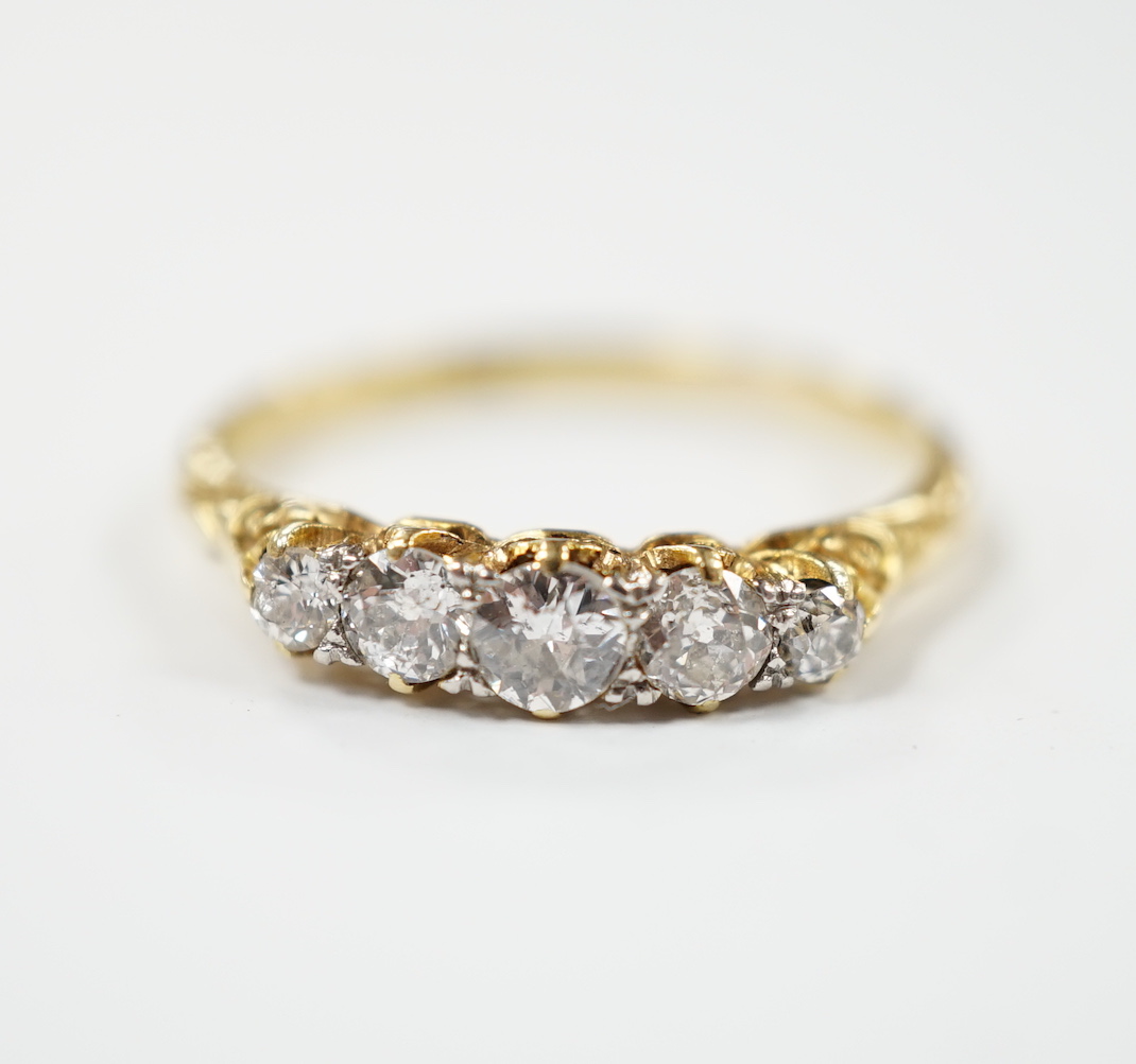 An 18ct and graduated five stone diamond set half hoop ring, size P/Q, gross weight 2.7 grams.                                                                                                                              