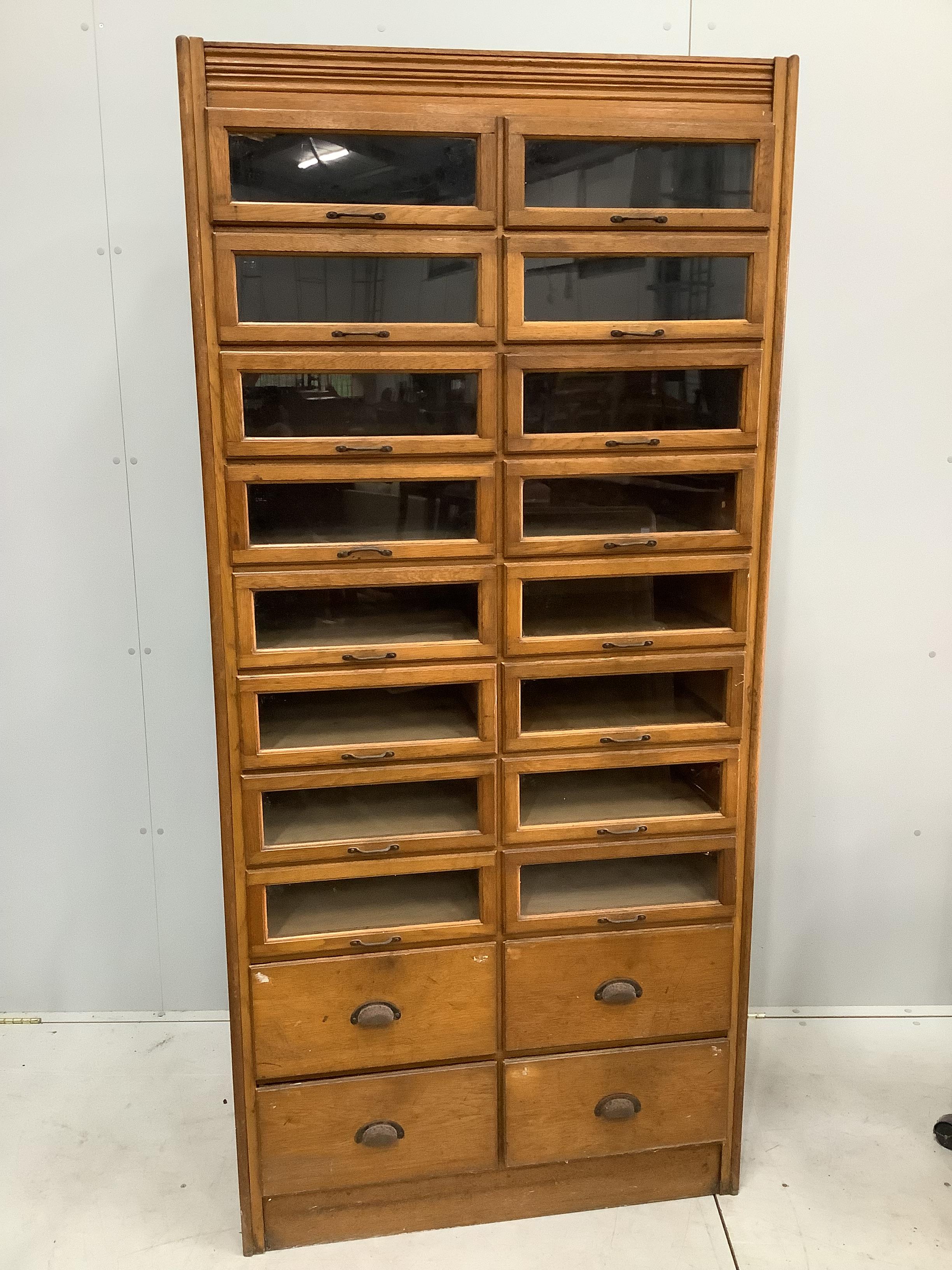 A mid century oak twenty drawer haberdashery cabinet, width 92cm, depth 51cm, height 197cm                                                                                                                                  