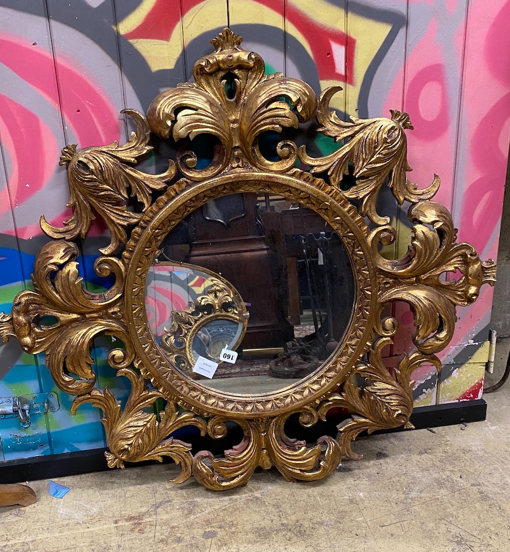 A circular wall mirror with carved giltwood frame, diameter 88cm                                                                                                                                                            