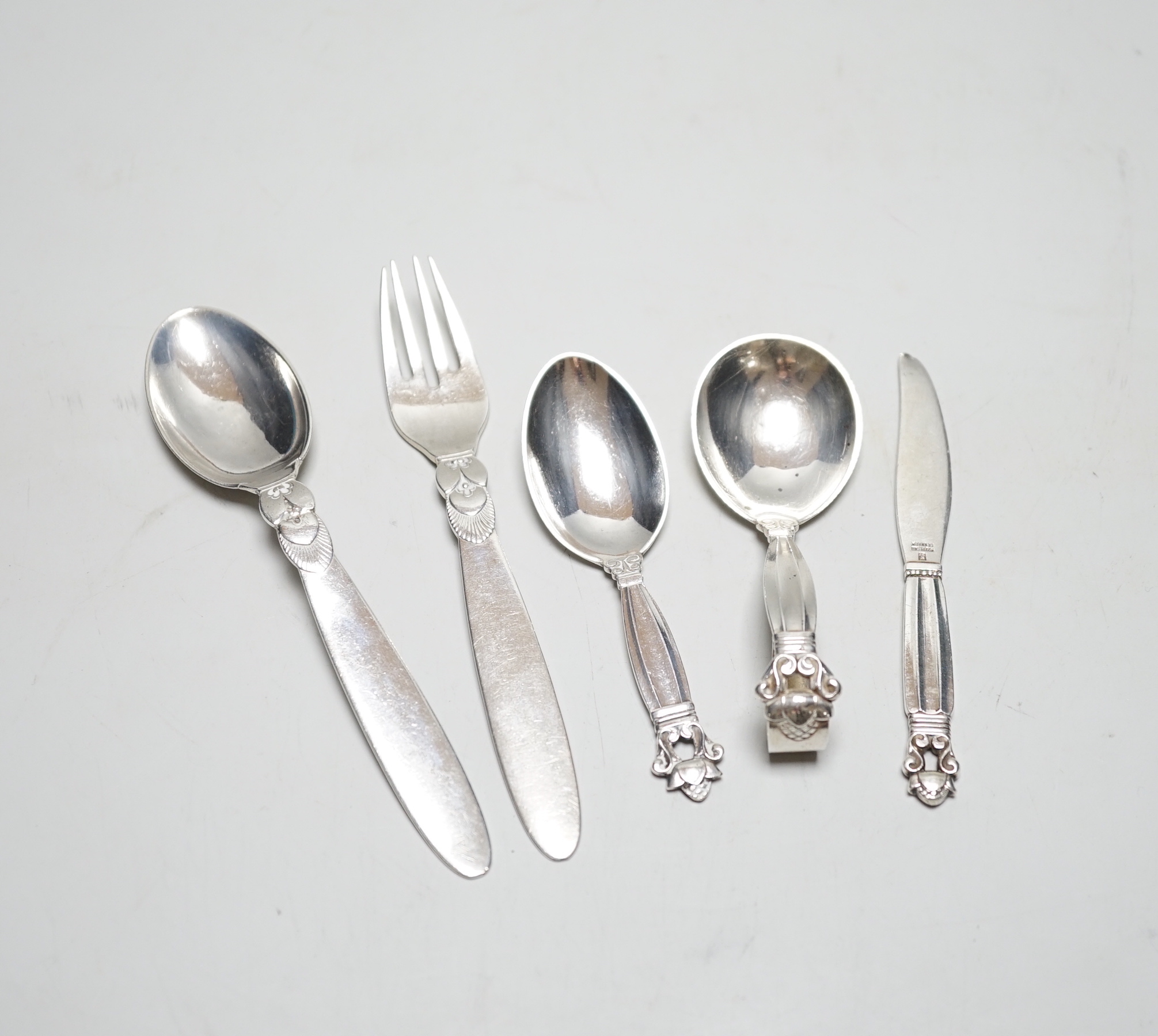 Five assorted items of Georg Jensen flatware including christening fork and spoon, caddy spoon, etc.                                                                                                                        