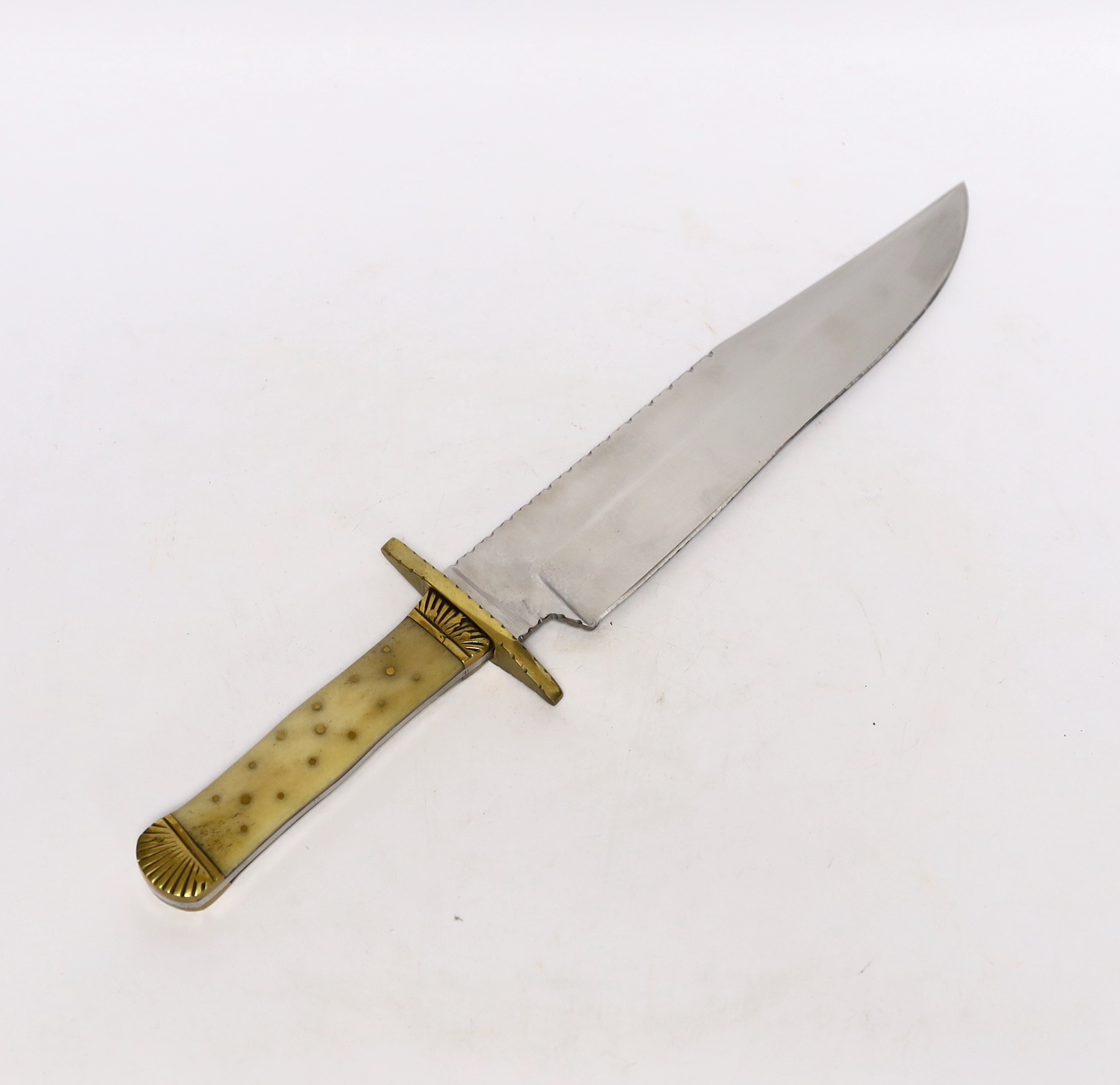 A Bowie knife with clip point blade, unsharpened false edge and decorative filework, marked made in Sheffield England, with bone grip, decorated with brass pins, brass guard and pommel, blade 25.5cm                      