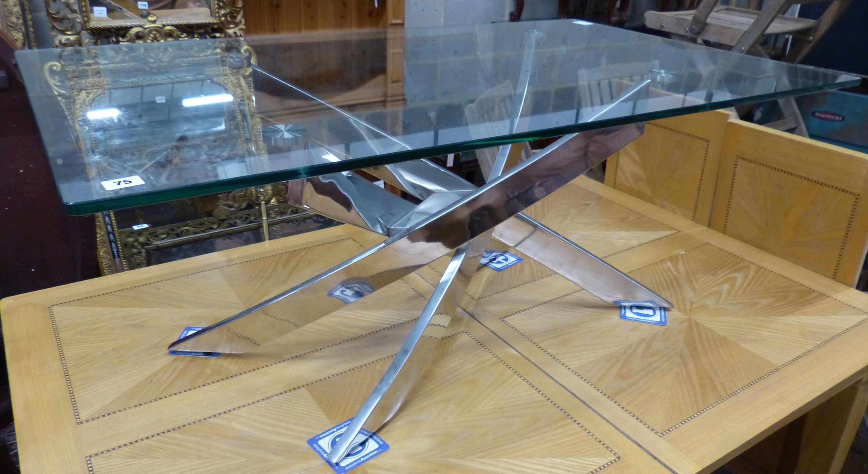 A modern plate glass topped coffee table, with a stainless steel underframe, W.120cm D.70cm H.51cm                                                                                                                          