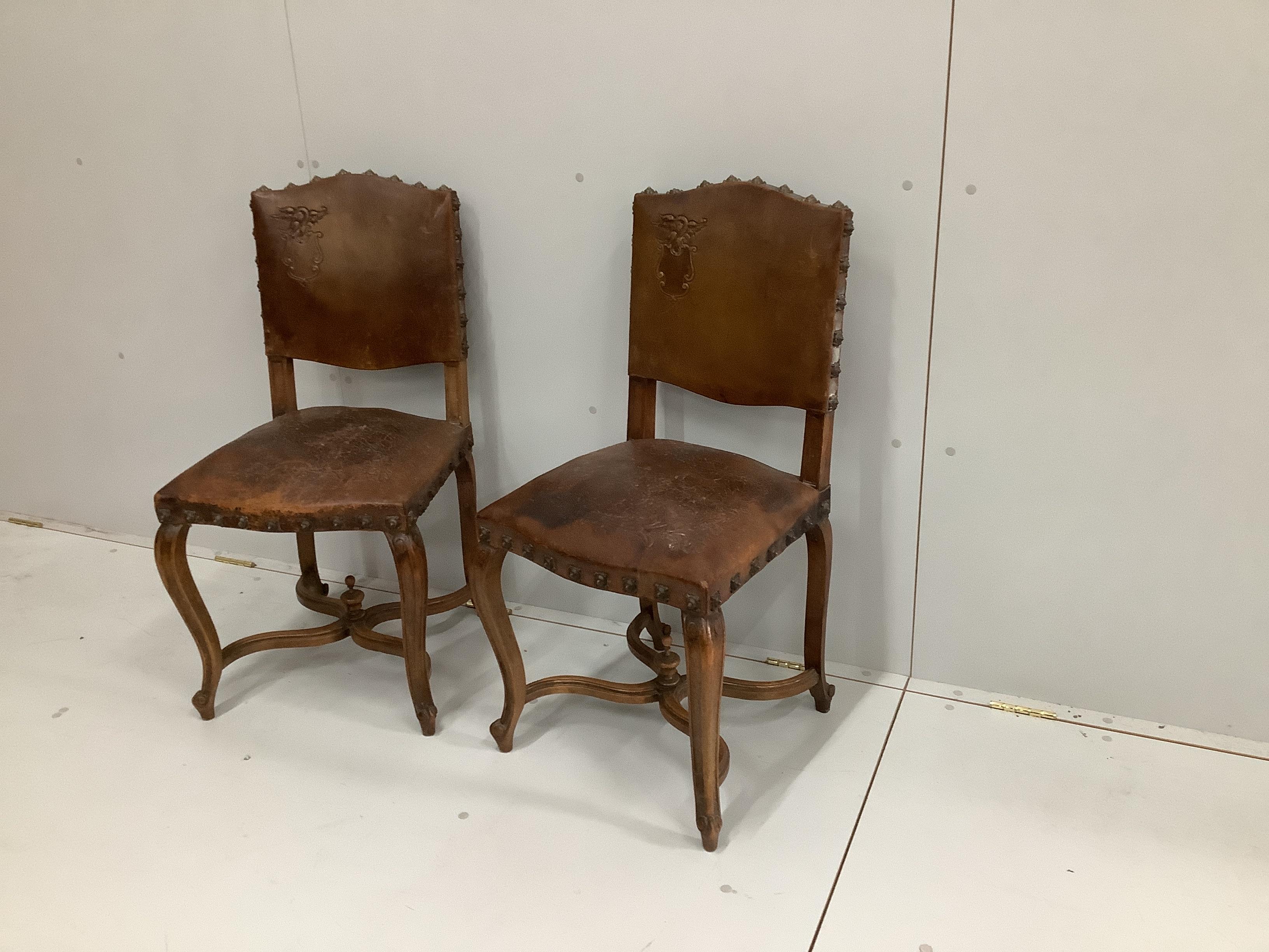 A pair of late 19th French Louis XV style carved oak dining chairs, with brown leather upholstery                                                                                                                           