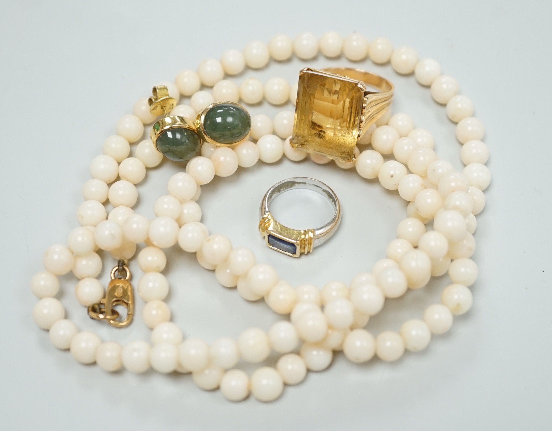 A modern 18k and single stone sapphire set child's ring, size G, a yellow metal and citrine set ring, size J, a pair of 585 and green cabochon set ear studs and a simulated coral bead necklace.                           