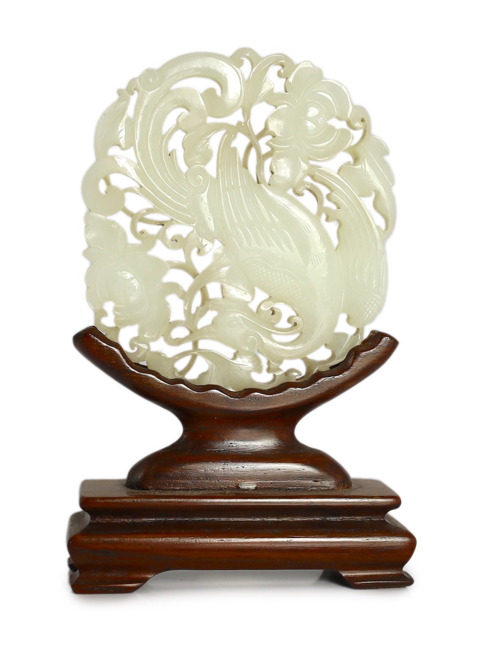 A Chinese white jade ‘phoenix and peony’ reticulated plaque, early 19th century, 6.9cm wide, wood stand                                                                                                                     