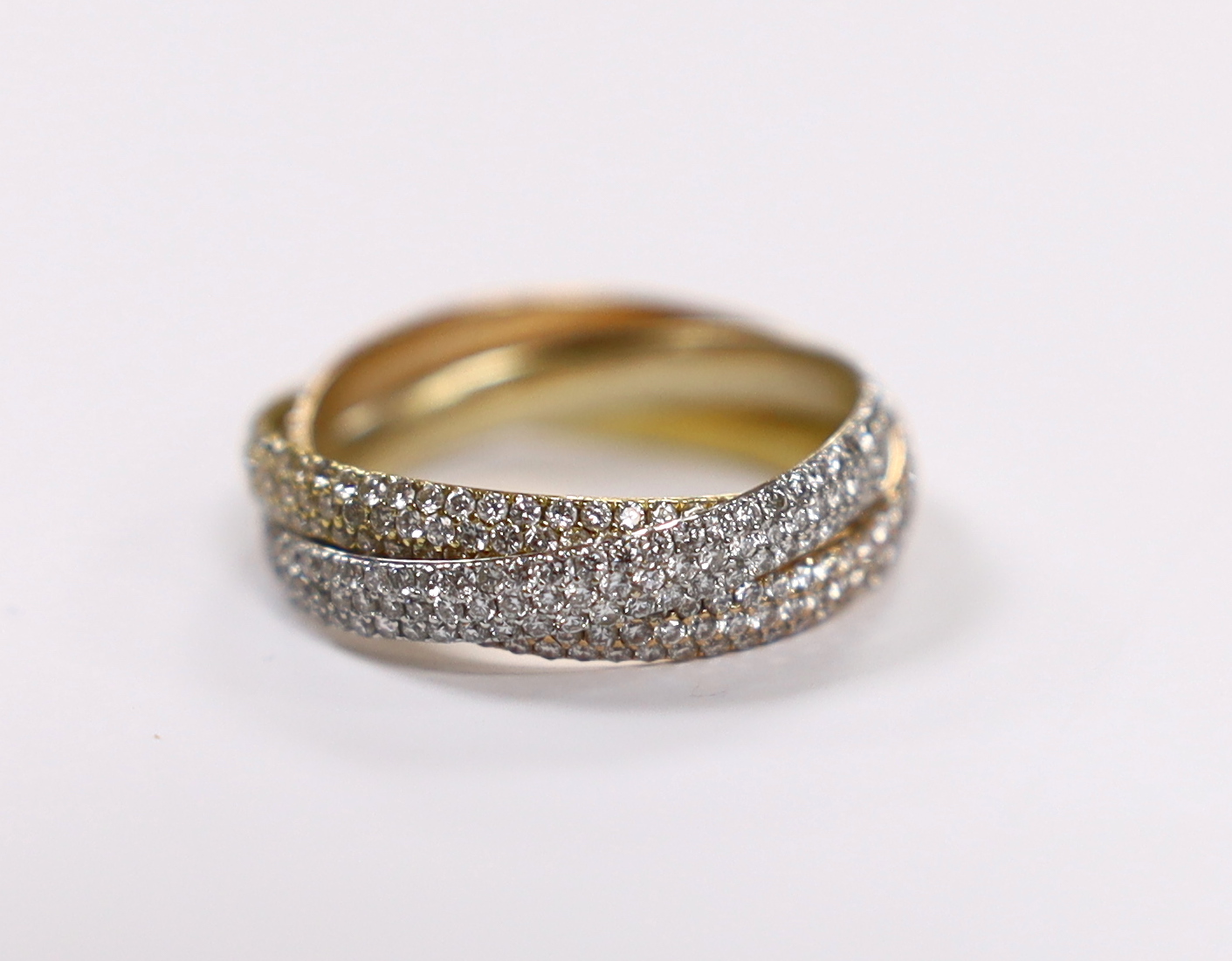 A three colour yellow metal and pave set diamond triple band 'Russian' wedding ring, size Q, gross weight 4.6 grams.                                                                                                        