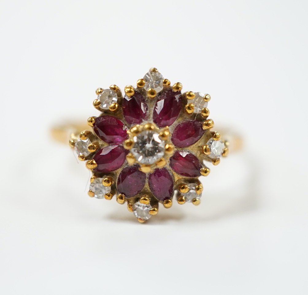 An 18ct, ruby and diamond set flower head cluster ring, size K, gross weight 3.7 grams.                                                                                                                                     