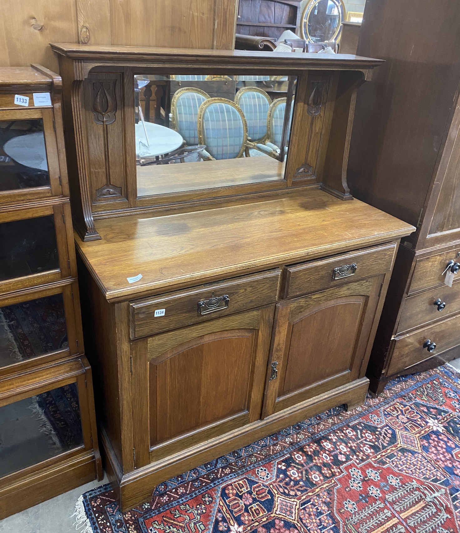 A late Victorian Art Nouveau oak sideboard, with a raised mirrored back, length 122cm, depth 52cm, height 152cm                                                                                                             
