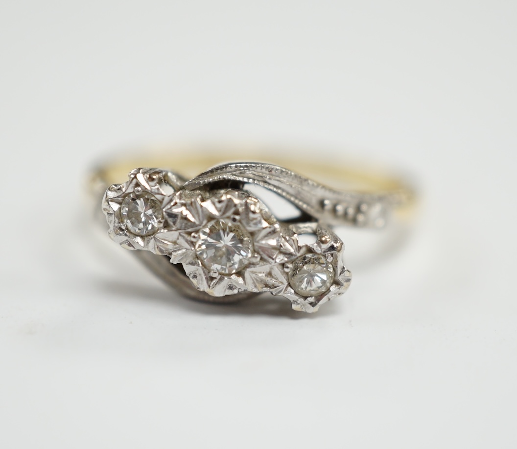 A mid to late 20th century 18ct gold and illusion set three stone diamond crossover ring, size N, gross weight 3.3 grams.                                                                                                   