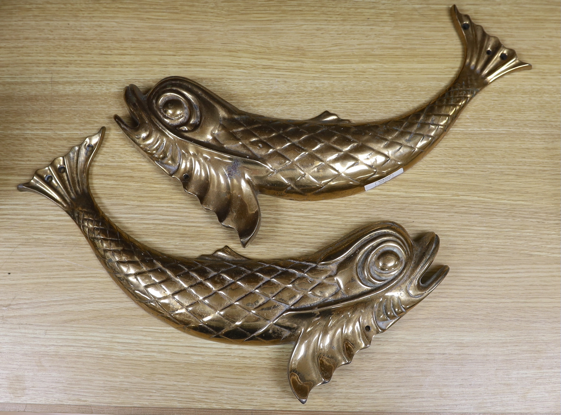 A heavy pair of brass ‘dolphin’ mounts, 46cm wide                                                                                                                                                                           