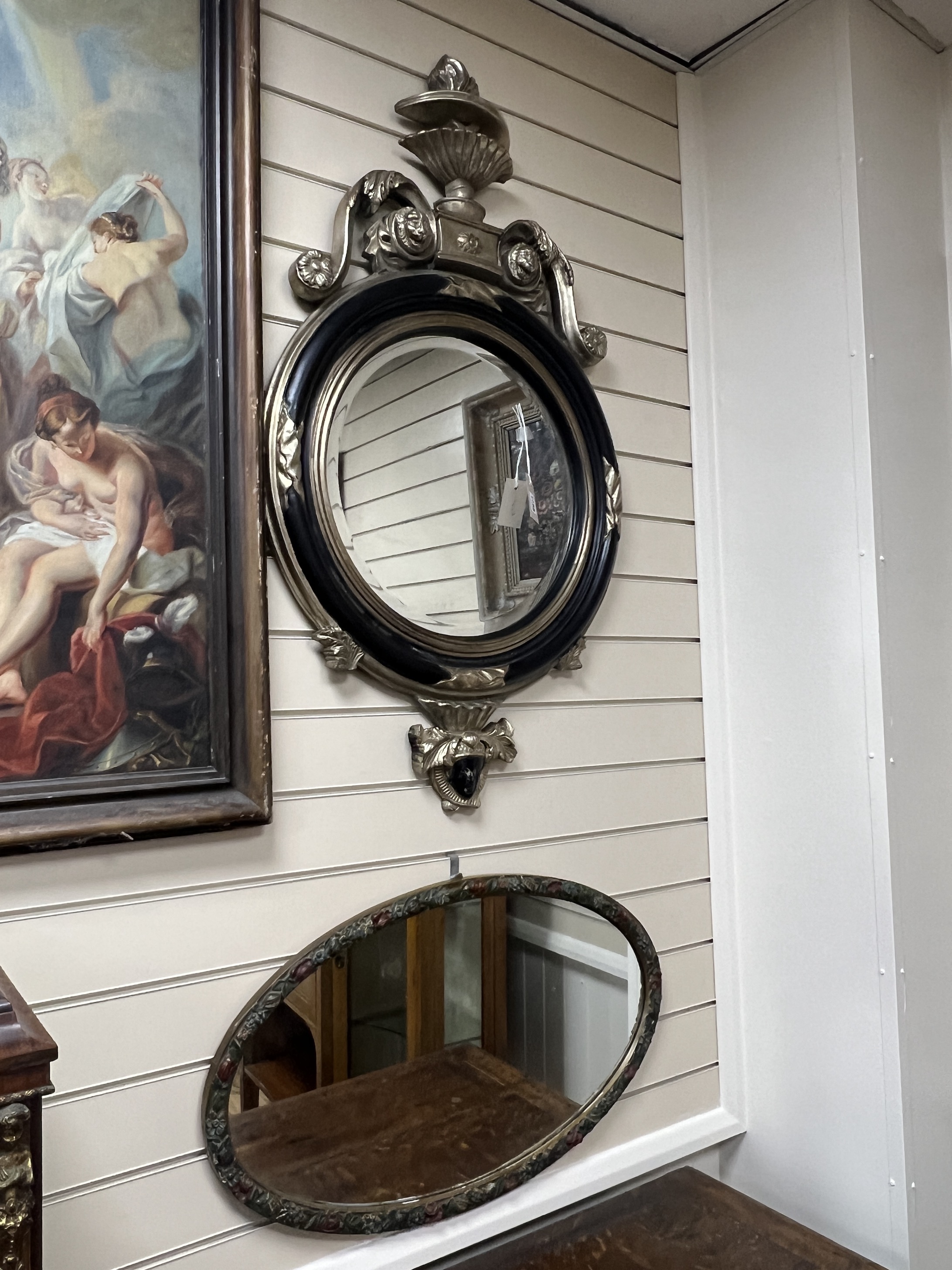An 18th century style circular wall mirror with vase pediment, width 60cm, height 104cm together with an oval floral moulded wall mirror                                                                                    