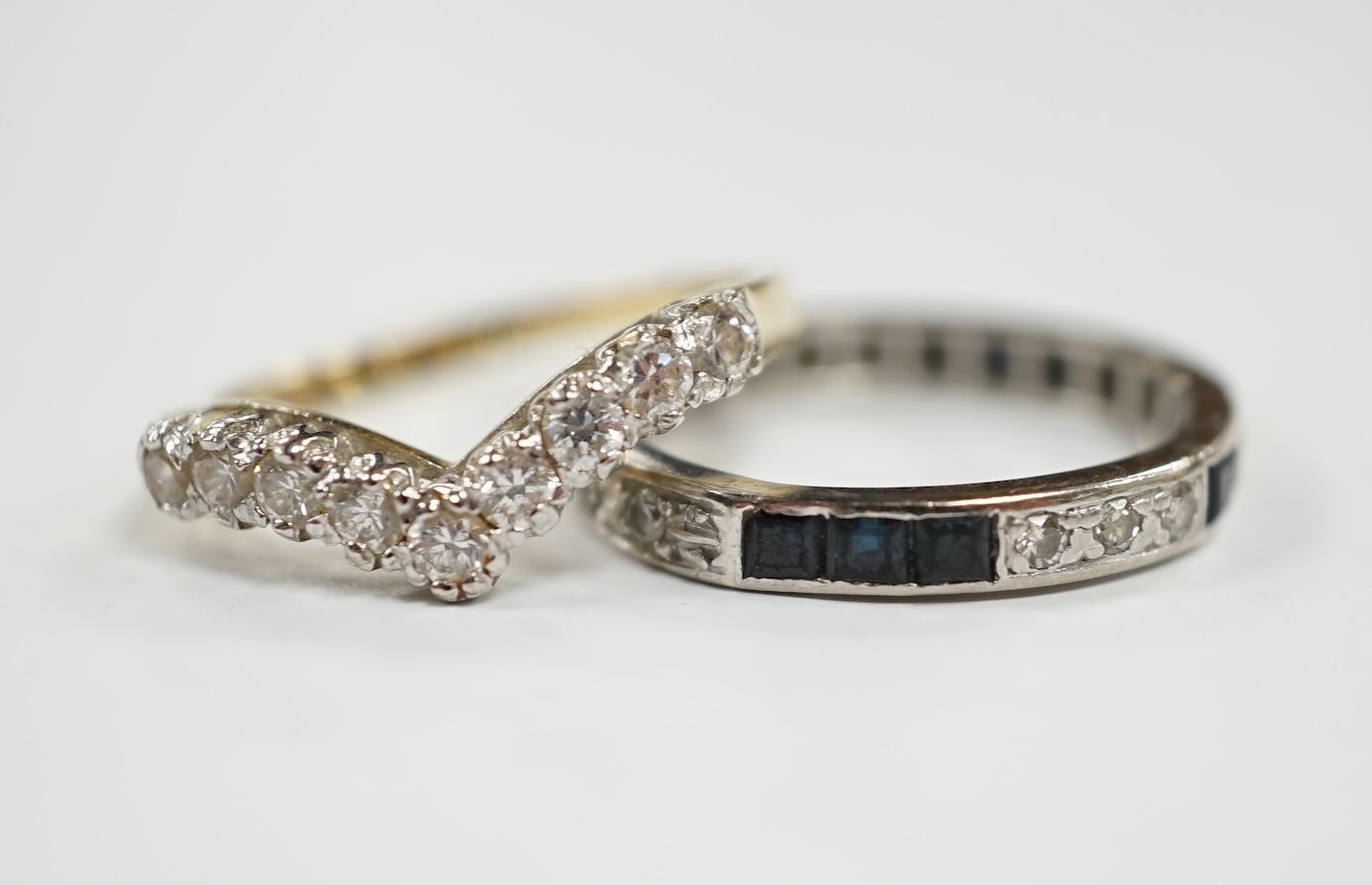A white metal sapphire and diamond set full eternity ring, size Q/R, gross weight 3.6 grams, together with a 14k and cubic zirconia set chevron ring, gross 2.8 grams. Condition - fair to poor                             