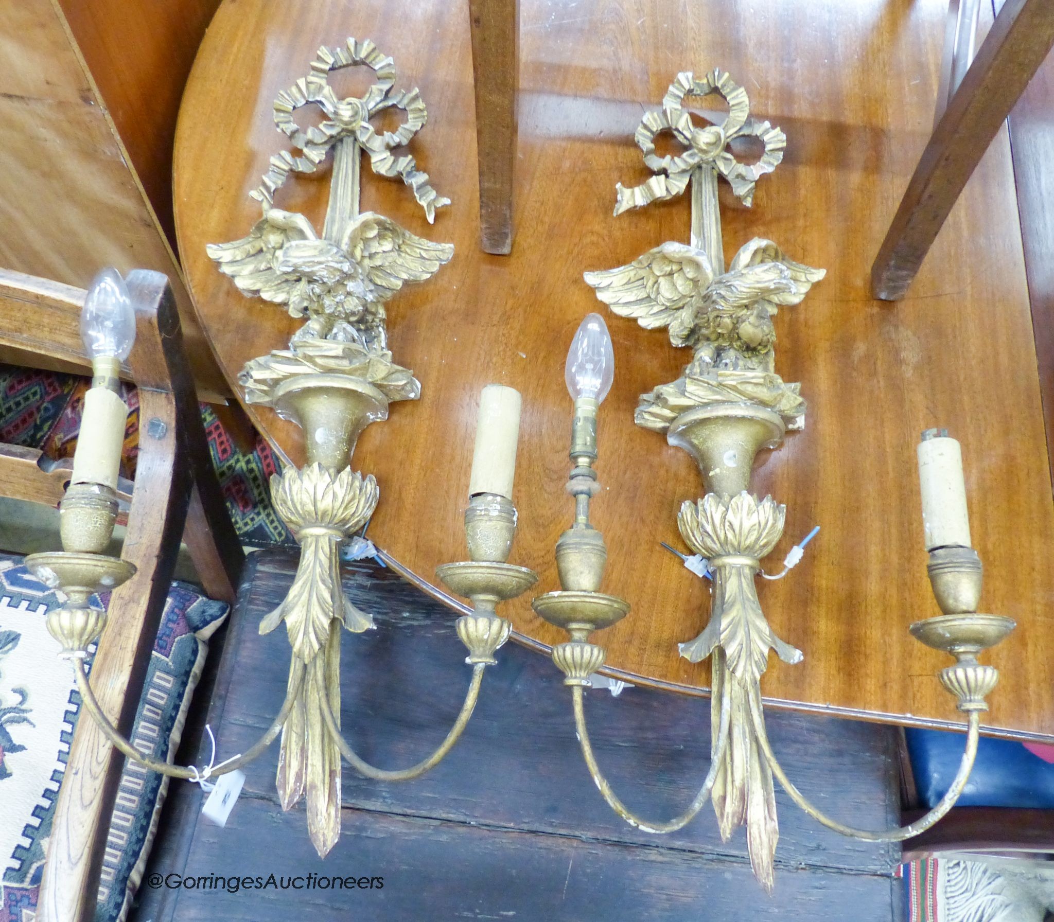 A pair of carved giltwood and gesso linenfold eagle two branch wall lights, height 70cm                                                                                                                                     