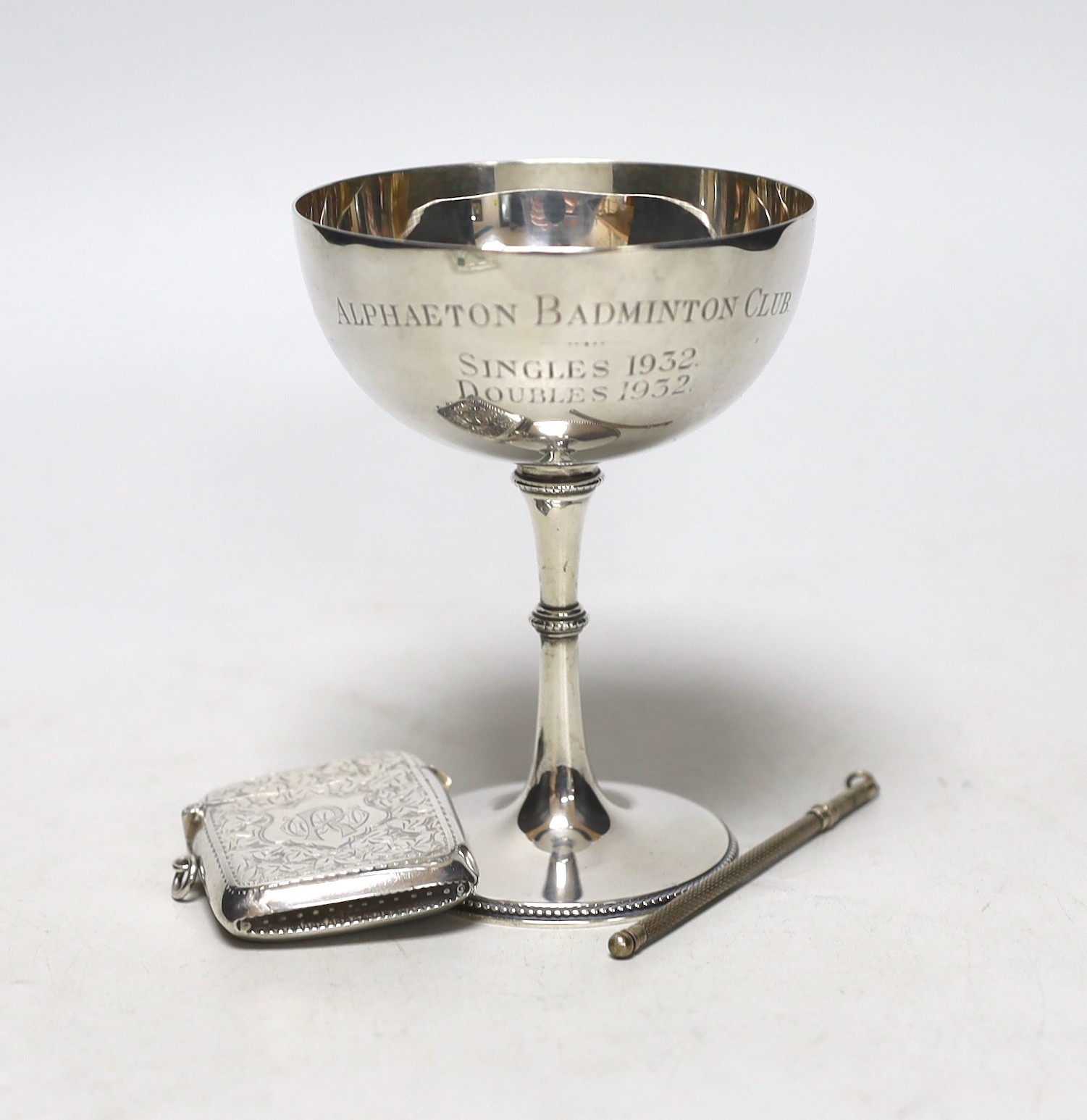 A George V silver Champagne coupe, Birmingham, 1923, 11.4cm with engraved inscription, a silver vesta case and a boxed swizzle stick.                                                                                       