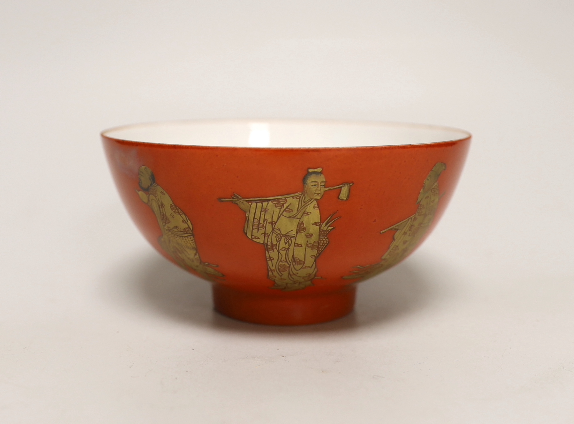 A Chinese coral red ground bowl, gilded with figures, 14cm diameter                                                                                                                                                         