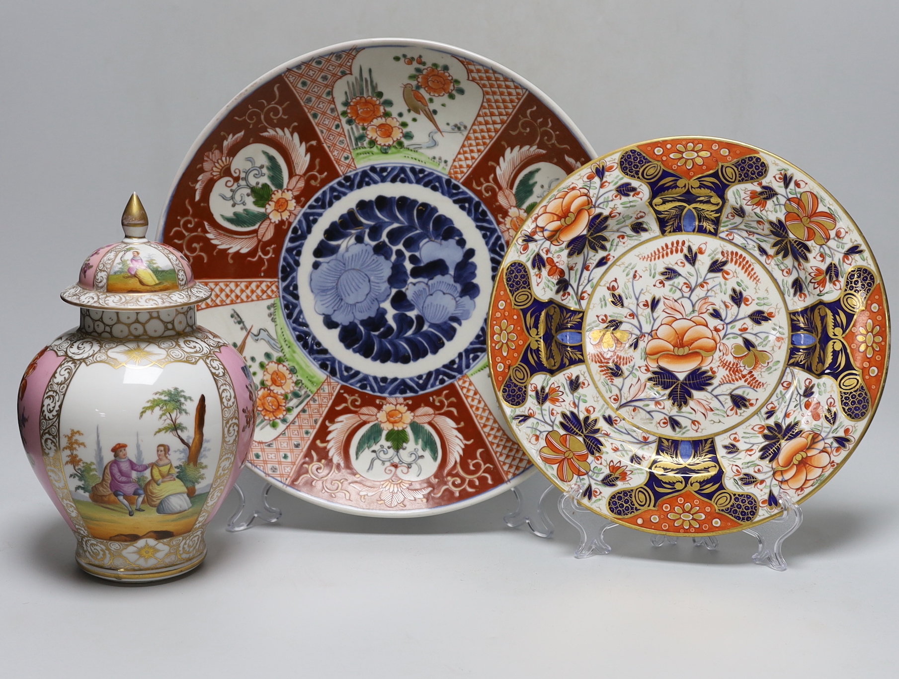 A Dresden pink ground jar and cover with gilt and floral decoration, 23cm tall, an Imari charger and Royal Crown Derby plate                                                                                                