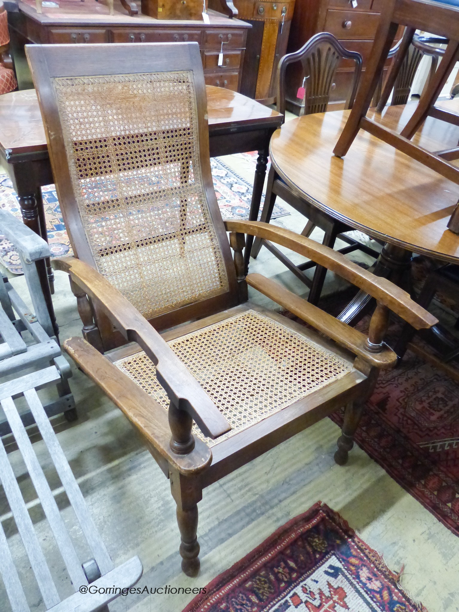 An early 20th century Colonial caned hardwood plantation chair                                                                                                                                                              