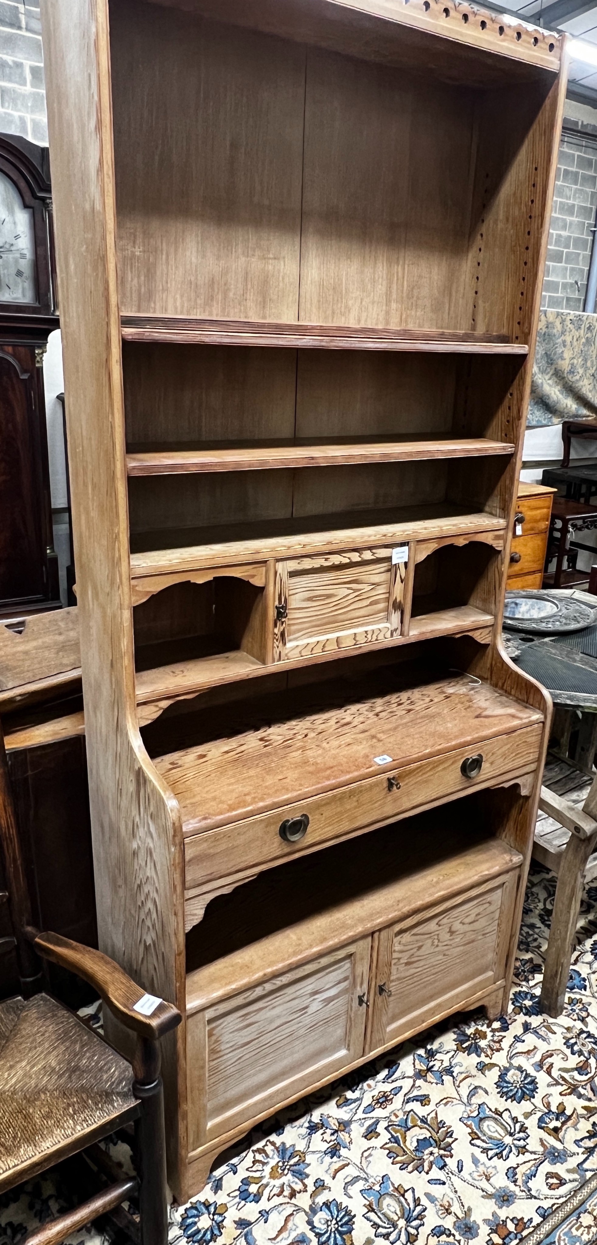 An Arts & Crafts pitch pine dresser with secretaire drawer, length 92cm, depth 41cm, height 220cm                                                                                                                           