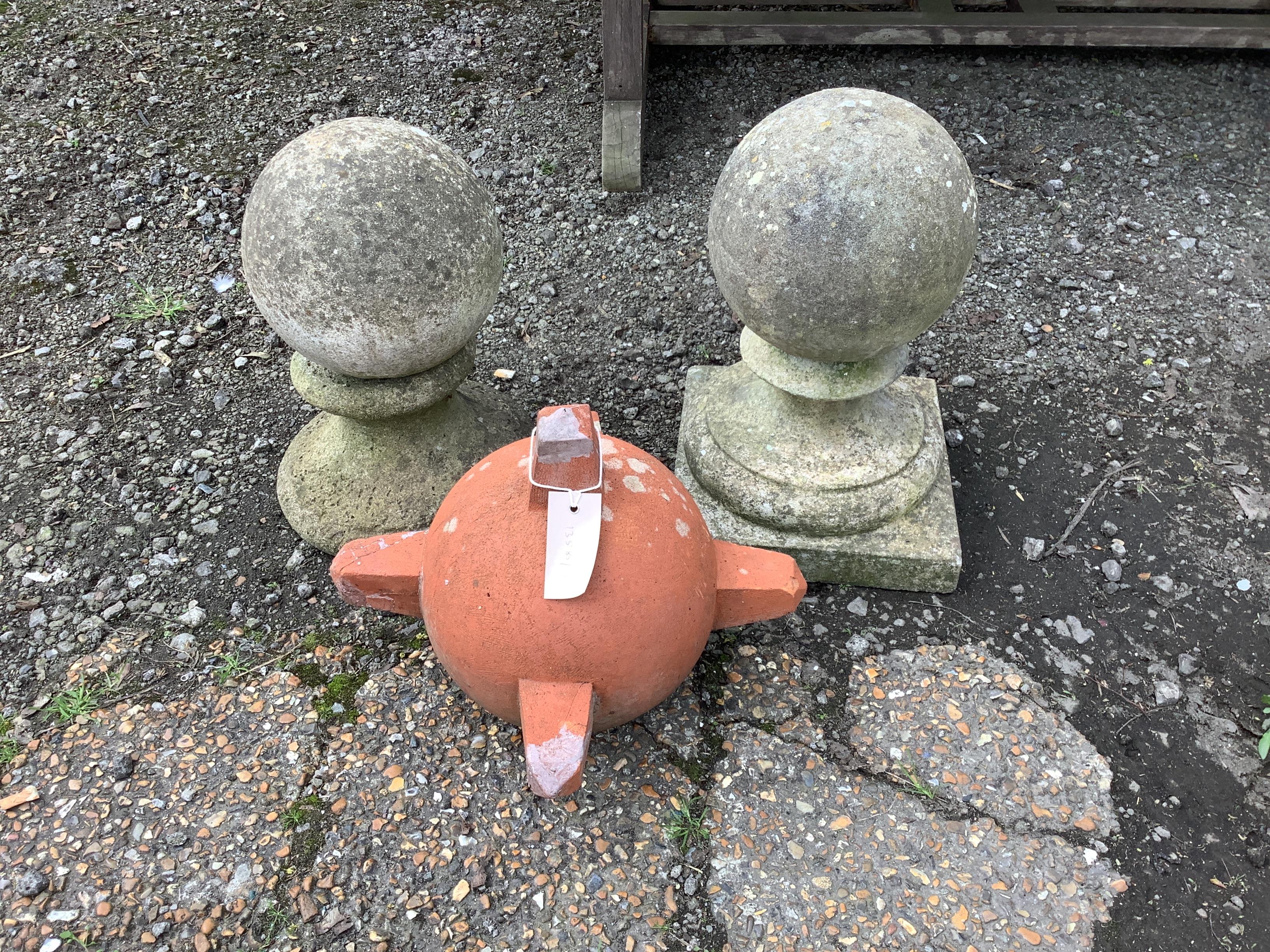 A pair of reconstituted stone ball finials, height 36cm together with a terracotta finial                                                                                                                                   