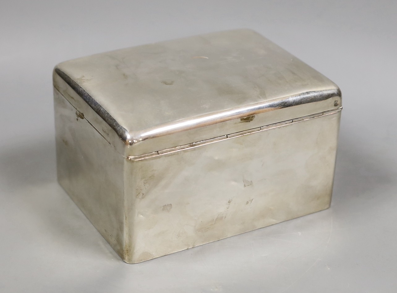 A George V silver mounted rectangular cigarette box, marks rubbed, maker's A & J Zimmerman, length 15.8cm.                                                                                                                  