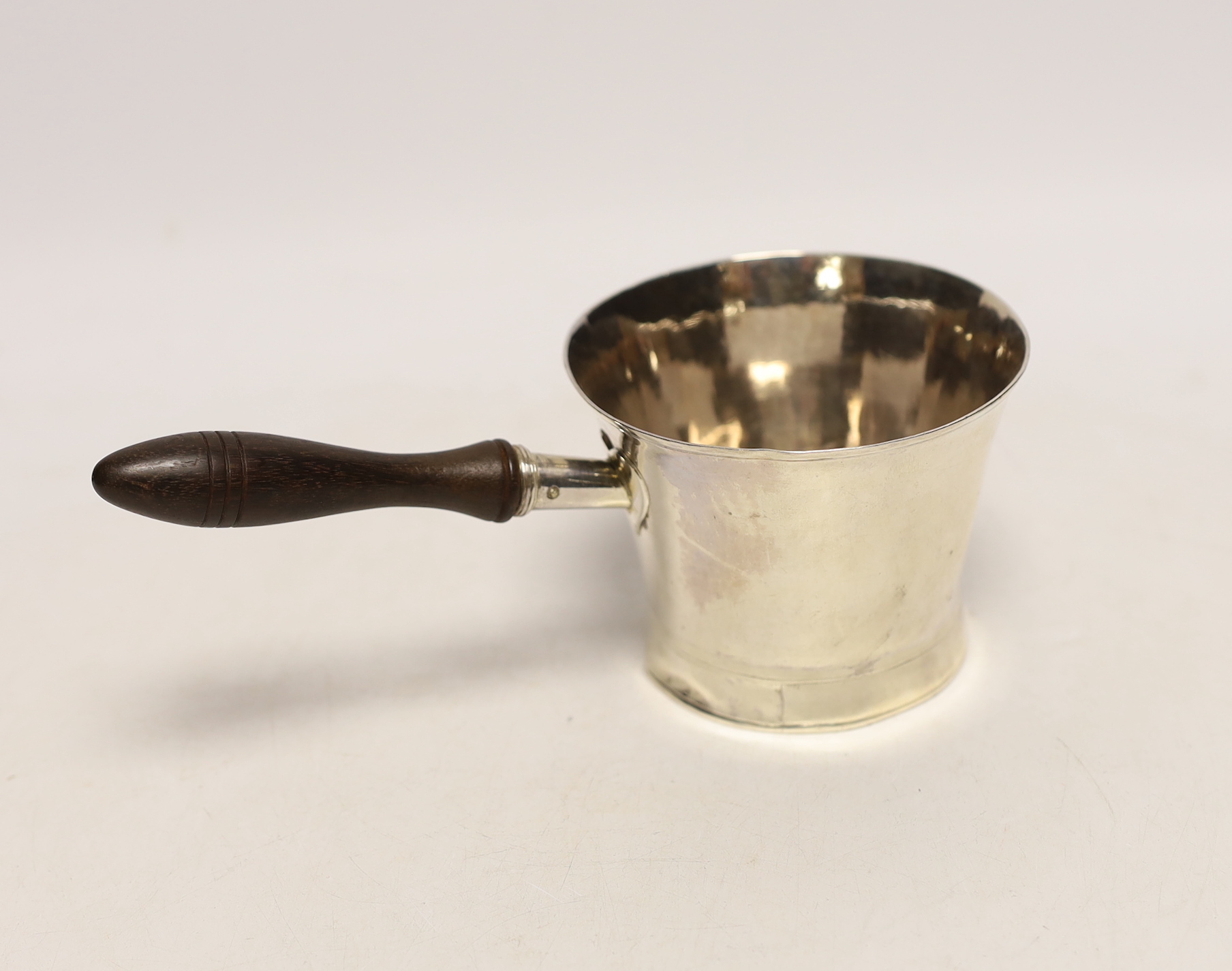 A George III silver tub shaped brandy warmer, with flared rim and turned wooden handle, Henry Chawner, London, 1791, length 19.2cm, gross weight 5.1oz.                                                                     