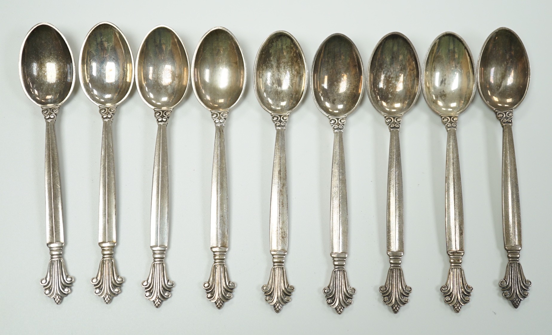 A set of nine 1950's Georg Jensen sterling coffee spoons, with London import marks and Georg Jensen box, 94mm, 93 grams.                                                                                                    