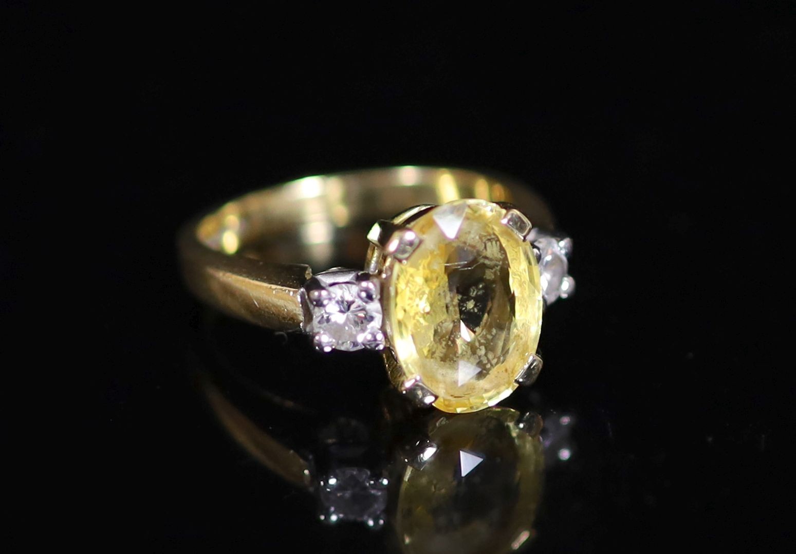 An 18ct gold, yellow sapphire and diamond set three stone ring                                                                                                                                                              