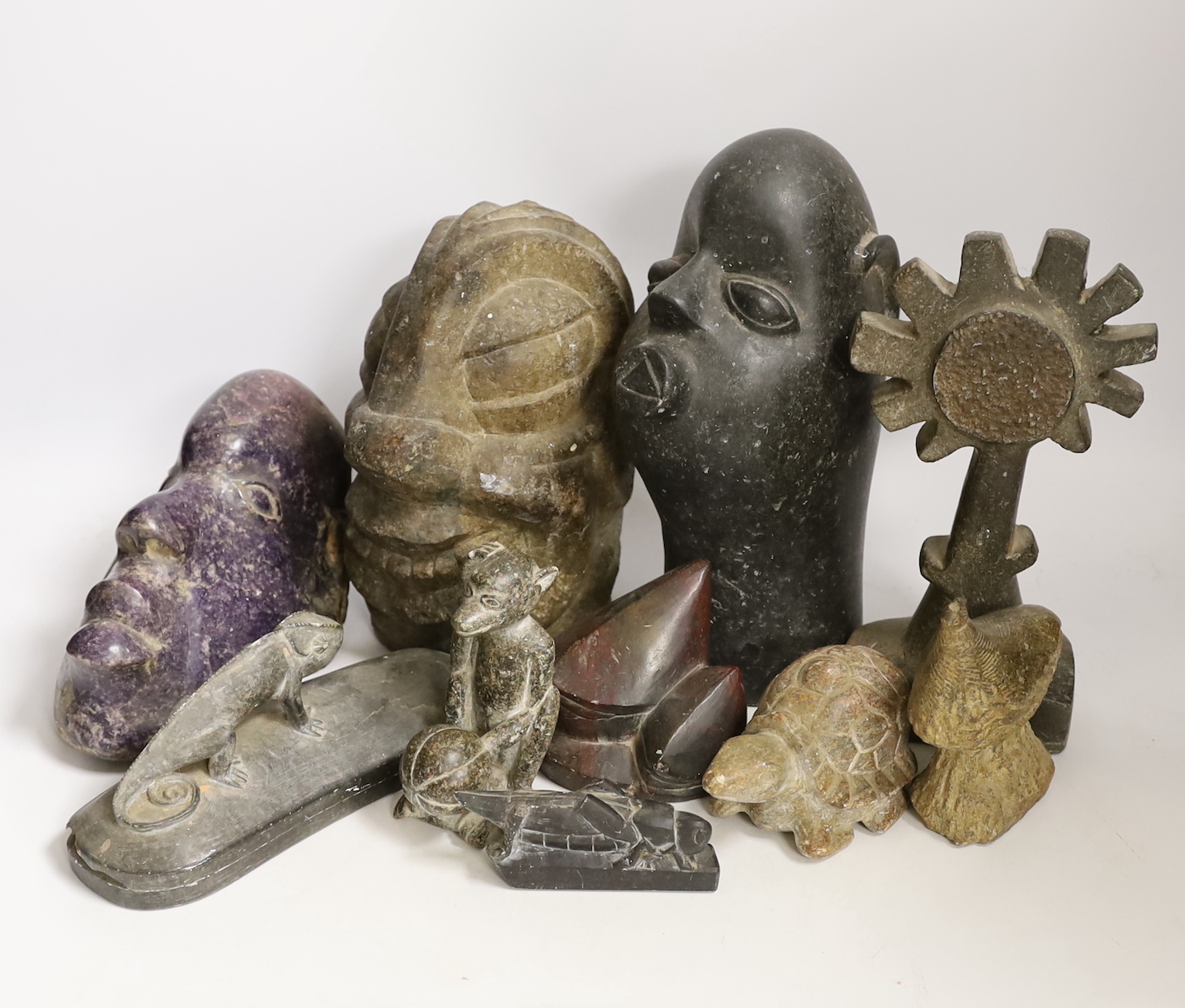 Ten Shona stone carvings, 1960s-70s, including three heads, the first in purple Lepodolite signed Conrad Nyagwande, one signed Amani the other initialled NM, a tortoise, a monkey, a gecko box and abstract sculpture forms