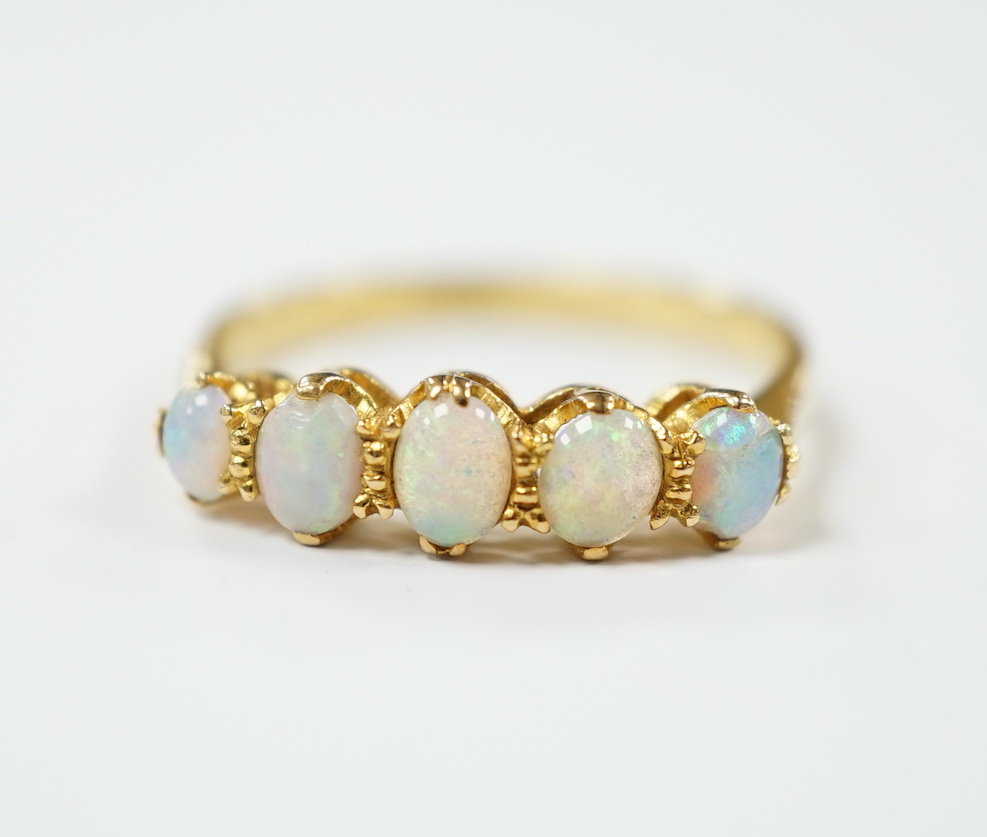 An 18ct and graduated five stone white opal set half hoop ring, size O, gross weight 2.7 grams.                                                                                                                             