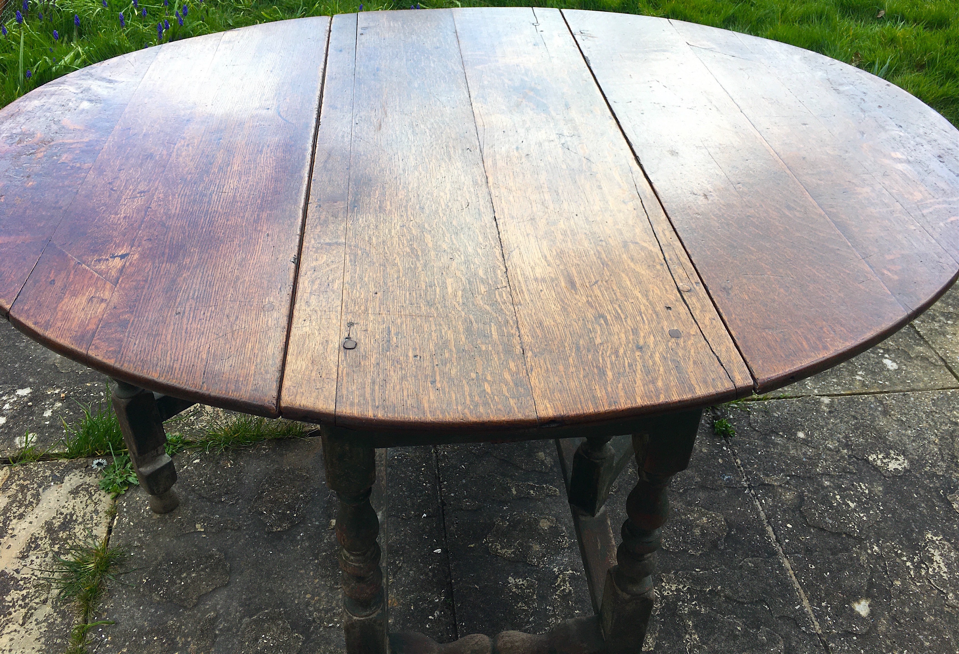 An 18th century oak gateleg dining table, the turned underframe with traces of old paint, length 123cm, depth extended 134cm, height 72cm *Please note the sale commences at 9am.                                           