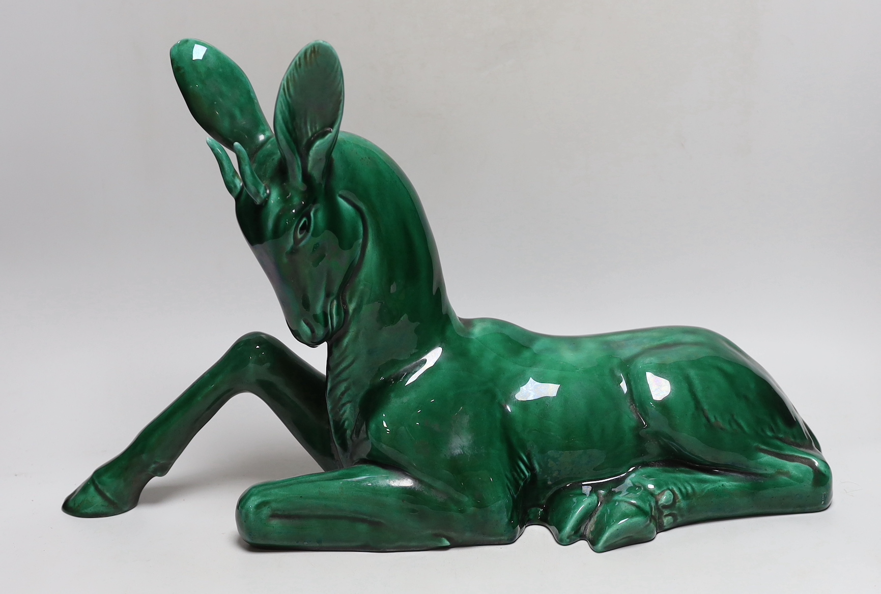 A French Art Deco large green glazed ceramic model of a seated deer, 50cm wide                                                                                                                                              