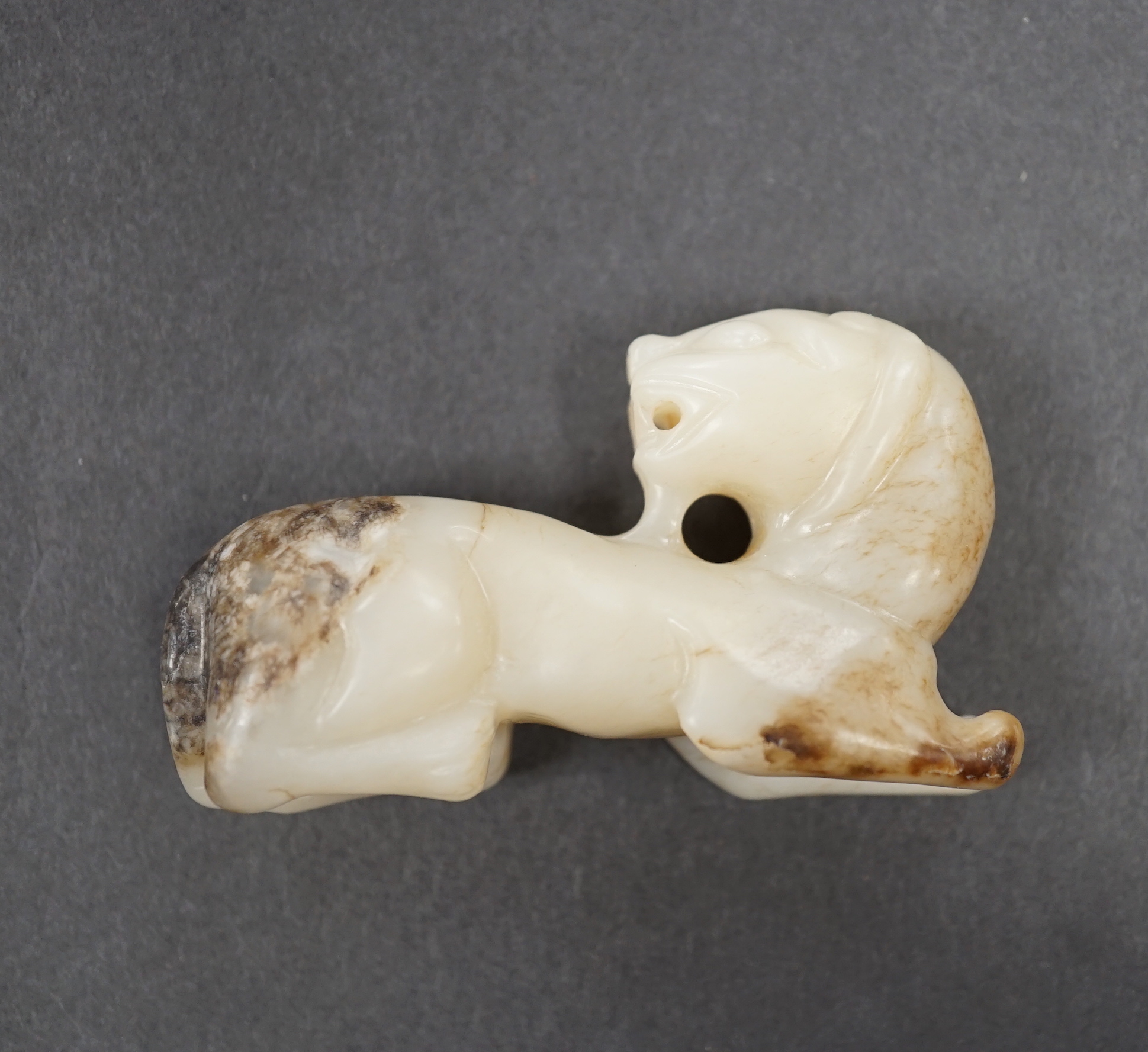 A Chinese white jade and black jade mythical beast, 7cm long                                                                                                                                                                