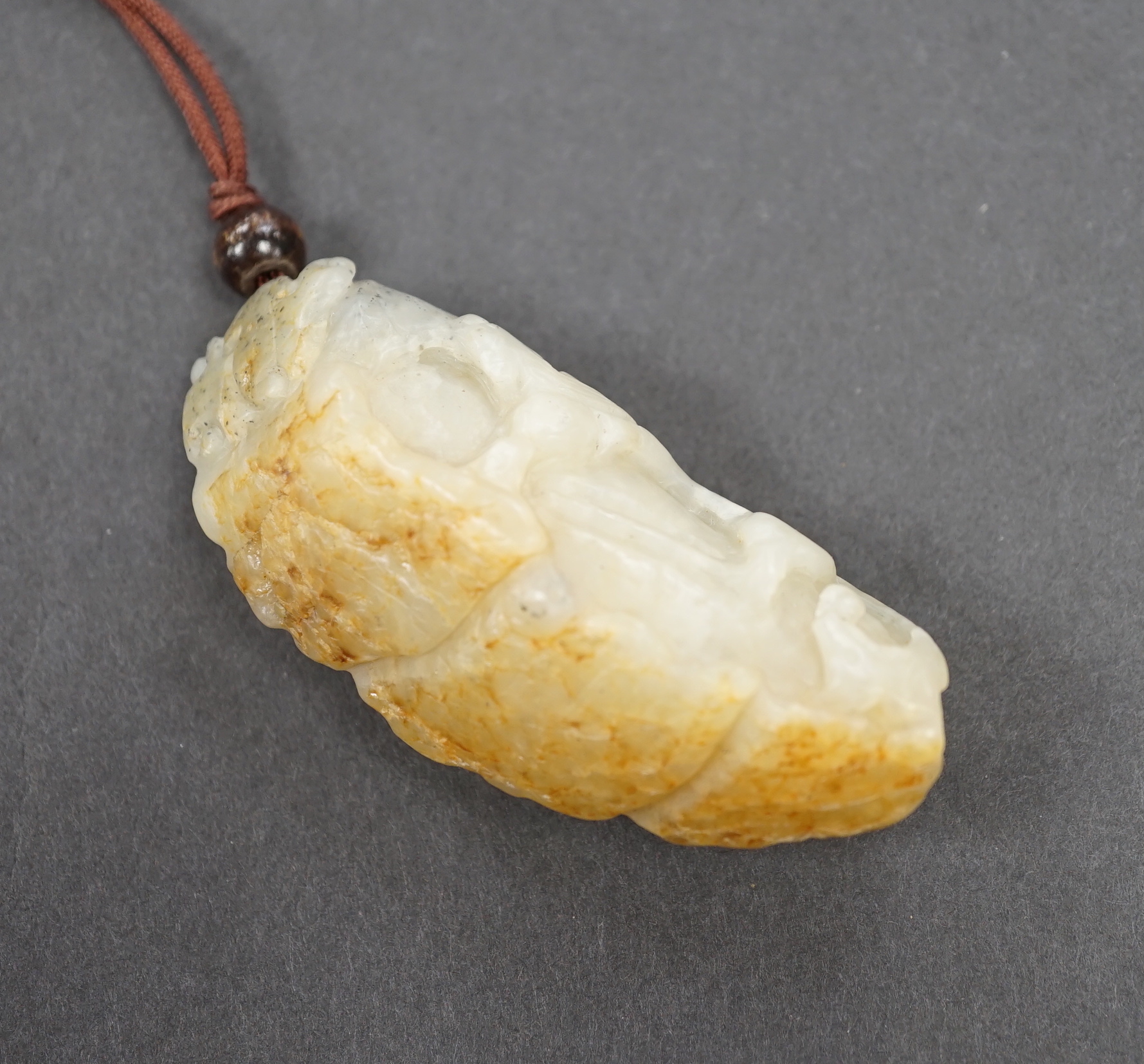 A Chinese white, grey and russet jade bitter melon with chilong, Qing dynasty, 7cm                                                                                                                                          