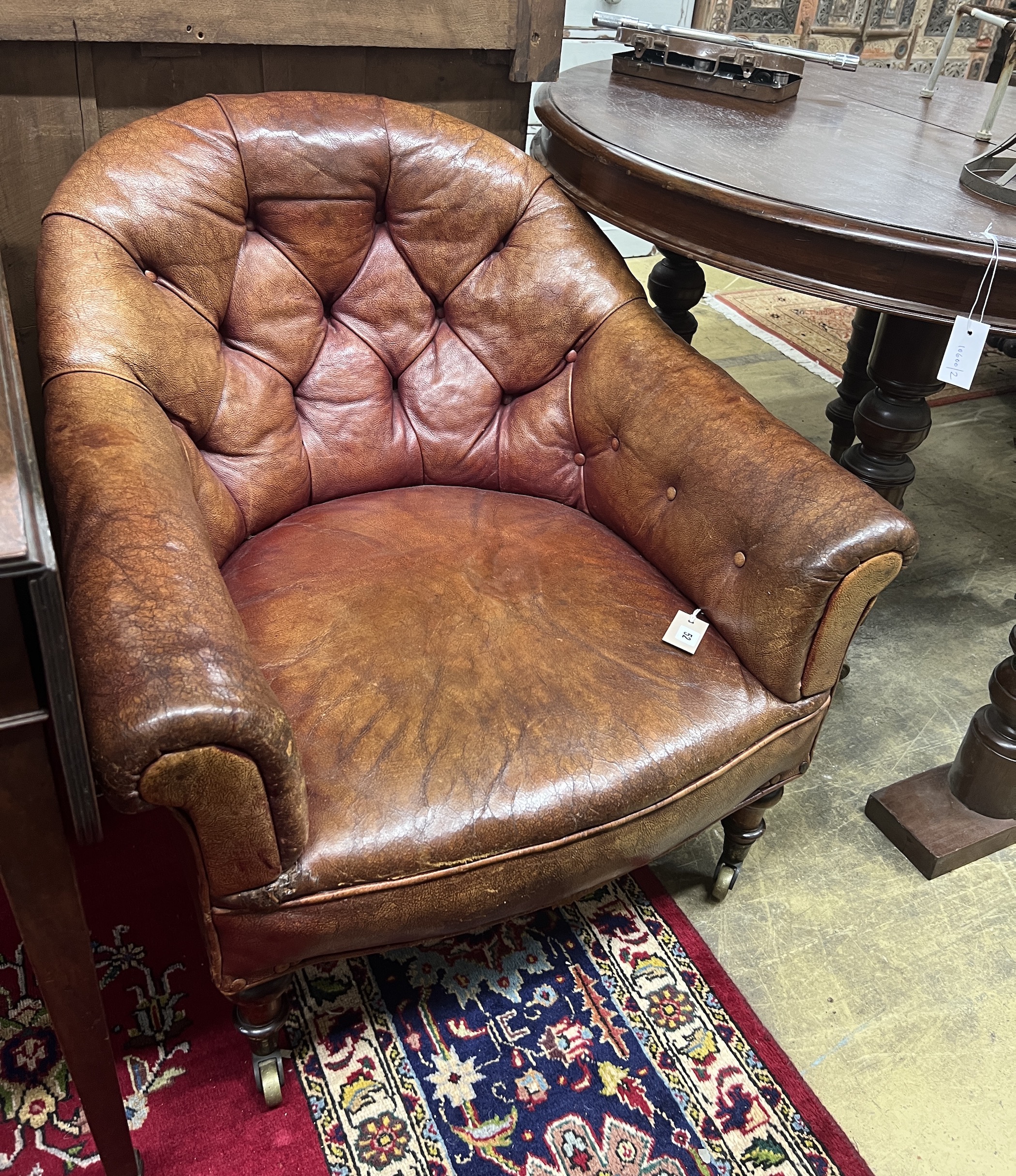 A Victorian mahogany buttoned faded red leather club chair, width 78cm, depth 83cm, height 75cm	                                                                                                                            