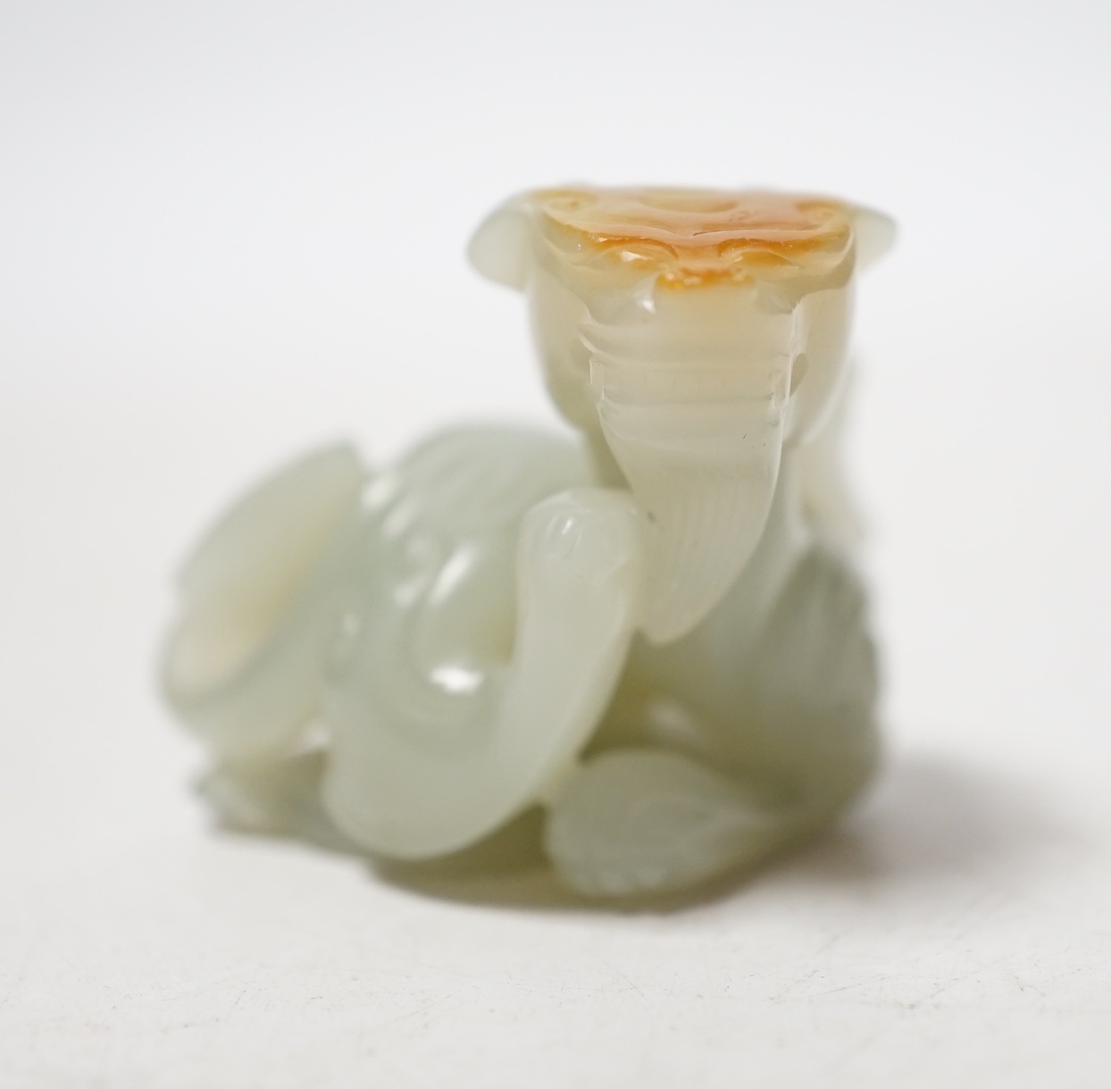 A Chinese pale celadon and russet skin jade figure of a dragon, 4cm high                                                                                                                                                    