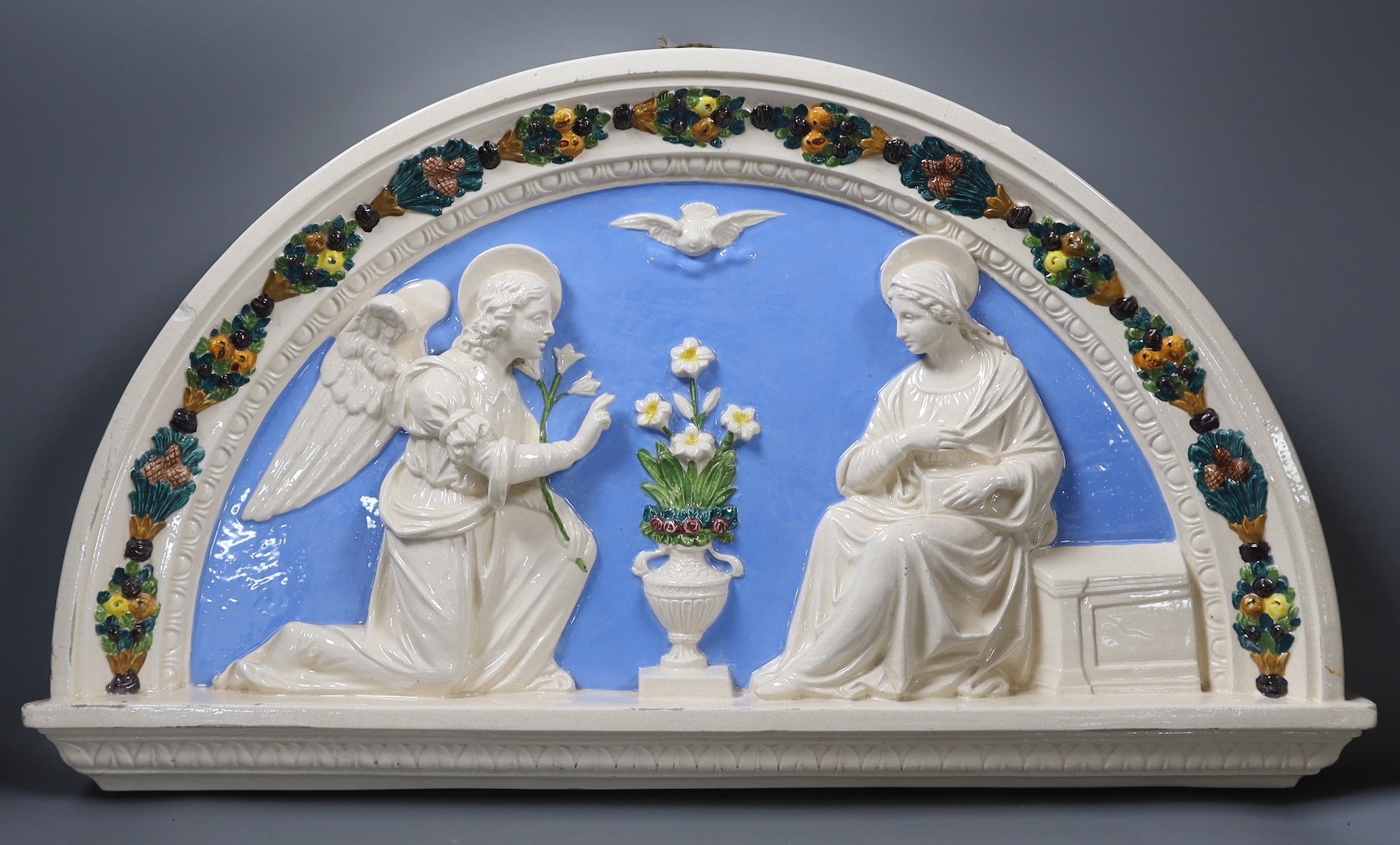 A Della Robbia style ceramic door pediment, 57.5cm wide                                                                                                                                                                     