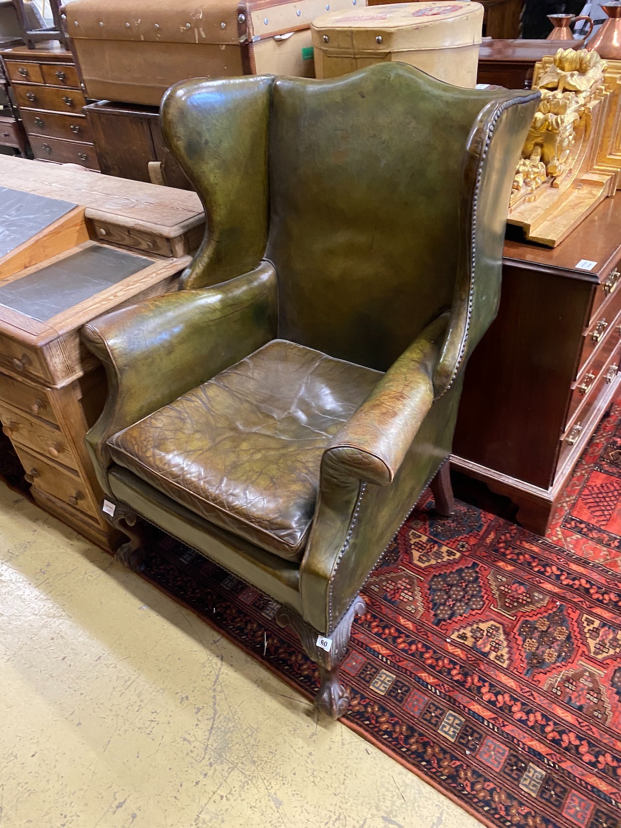 A George III style mahogany and olive green leather upholstered wing armchair, width 79cm, depth 78cm, height 114cm                                                                                                         