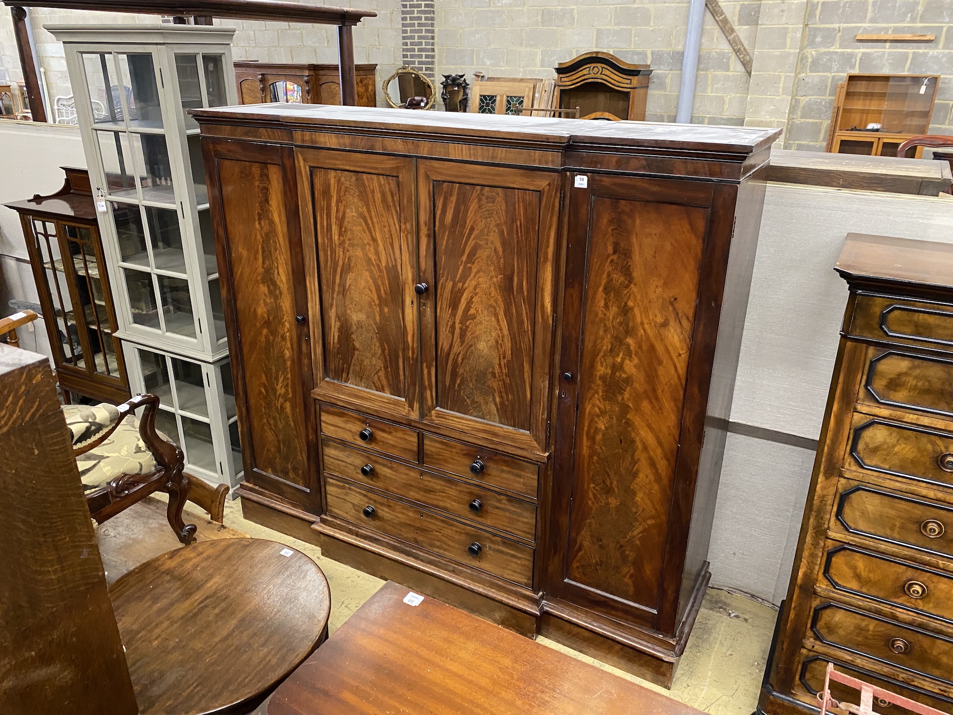 An early Victorian mahogany breakfront compactum wardrobe, width 220cm, depth 58cm, height 199cm                                                                                                                            