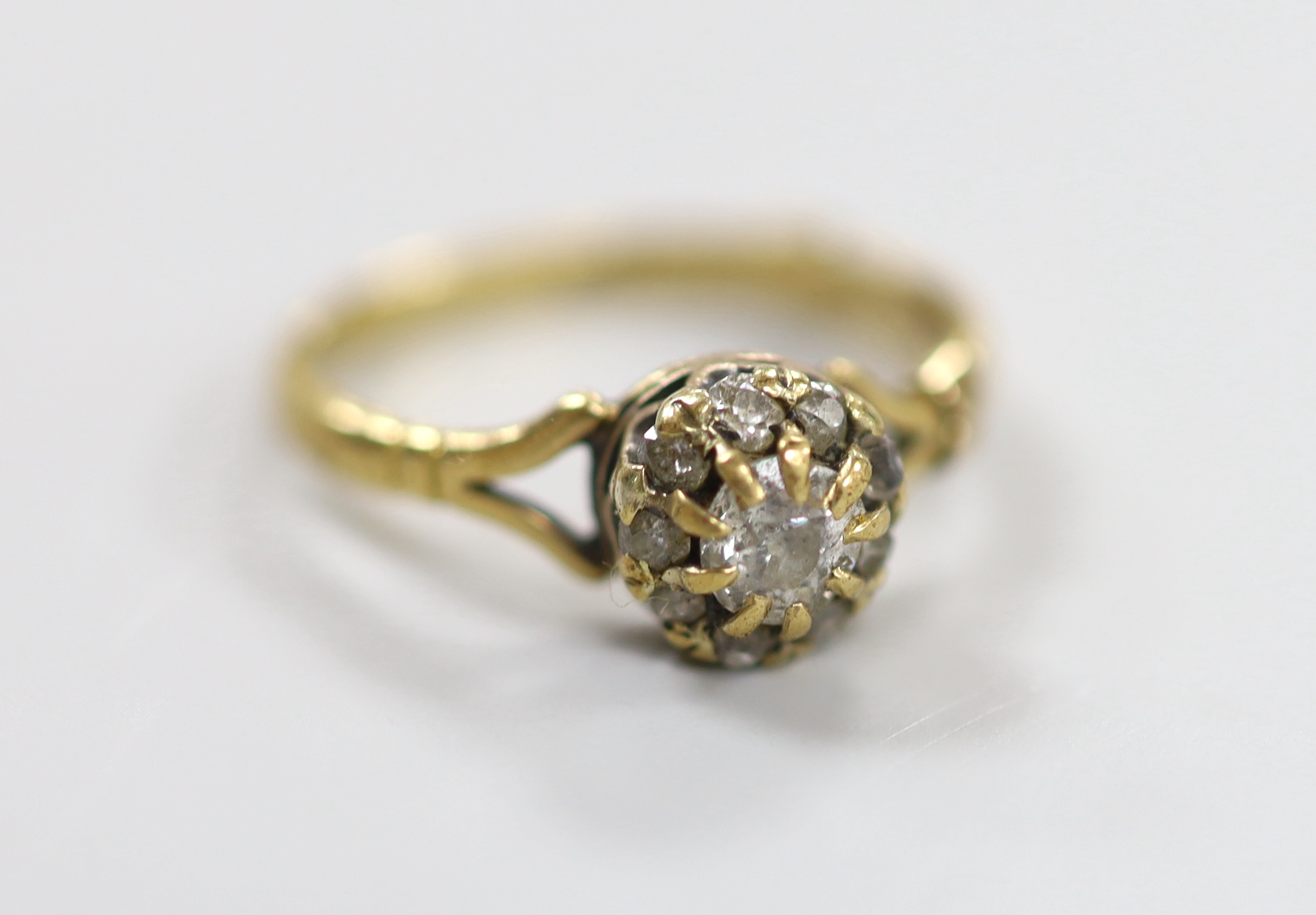 An 18ct and diamond cluster ring, size O, gross weight 2.7 grams.                                                                                                                                                           