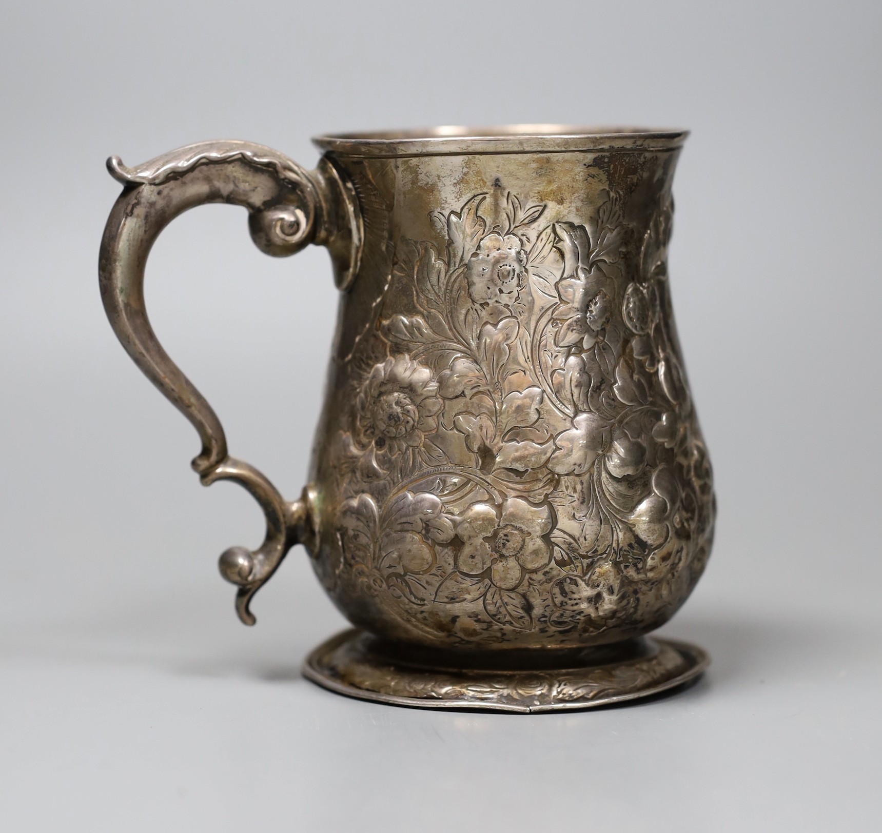 An early George III silver mug, with later-embossed floral detail, London 1762, 12cm.                                                                                                                                       