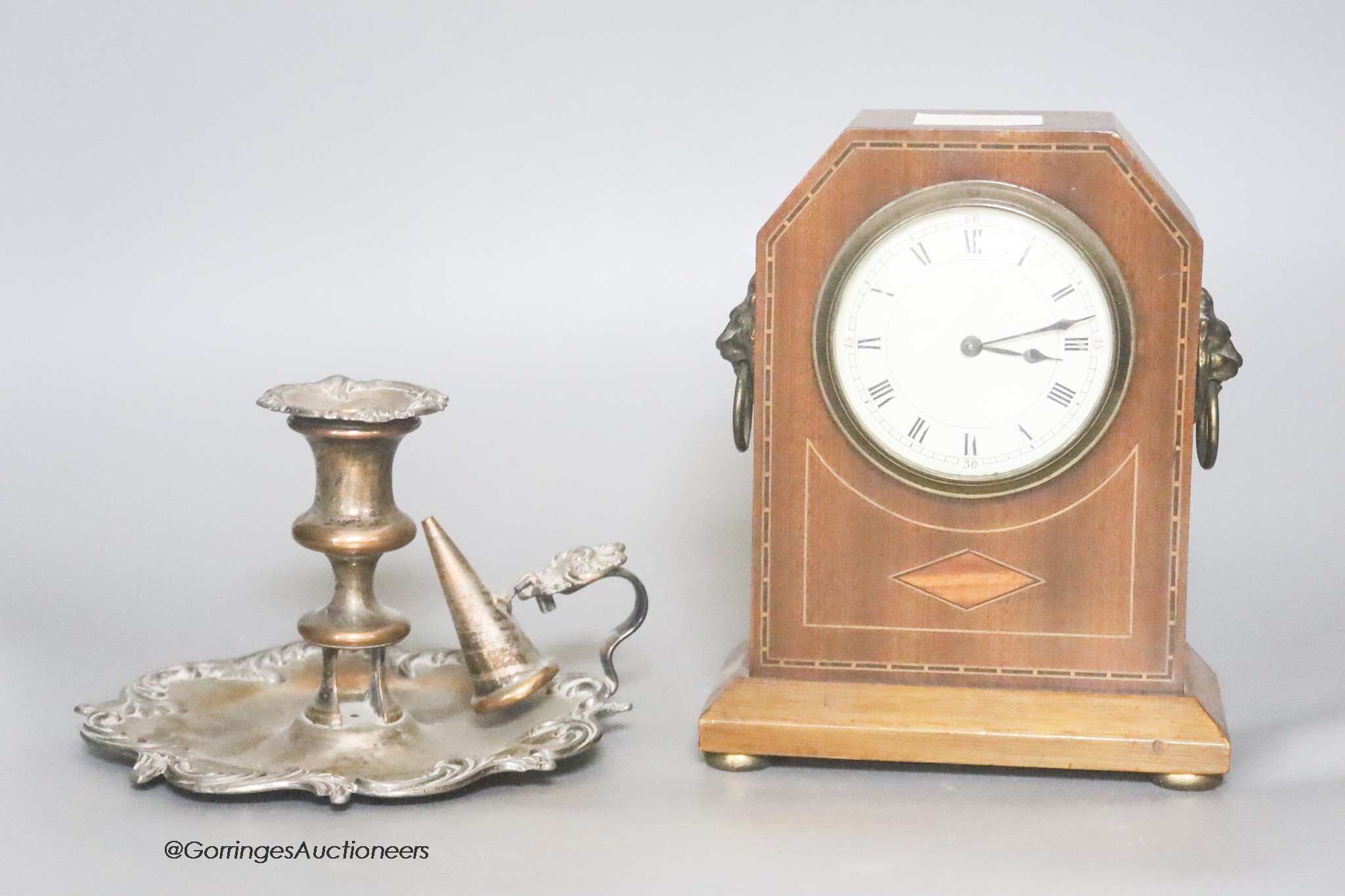 An Edwardian mahogany mantel timepiece, together with a silver plated chamberstick                                                                                                                                          