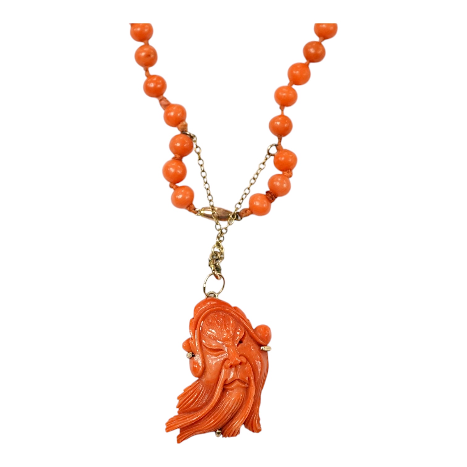 A single strand coral bead necklace, with a coral pendant carved as the face of a gentleman, overall 48cm. Condition - fair                                                                                                 