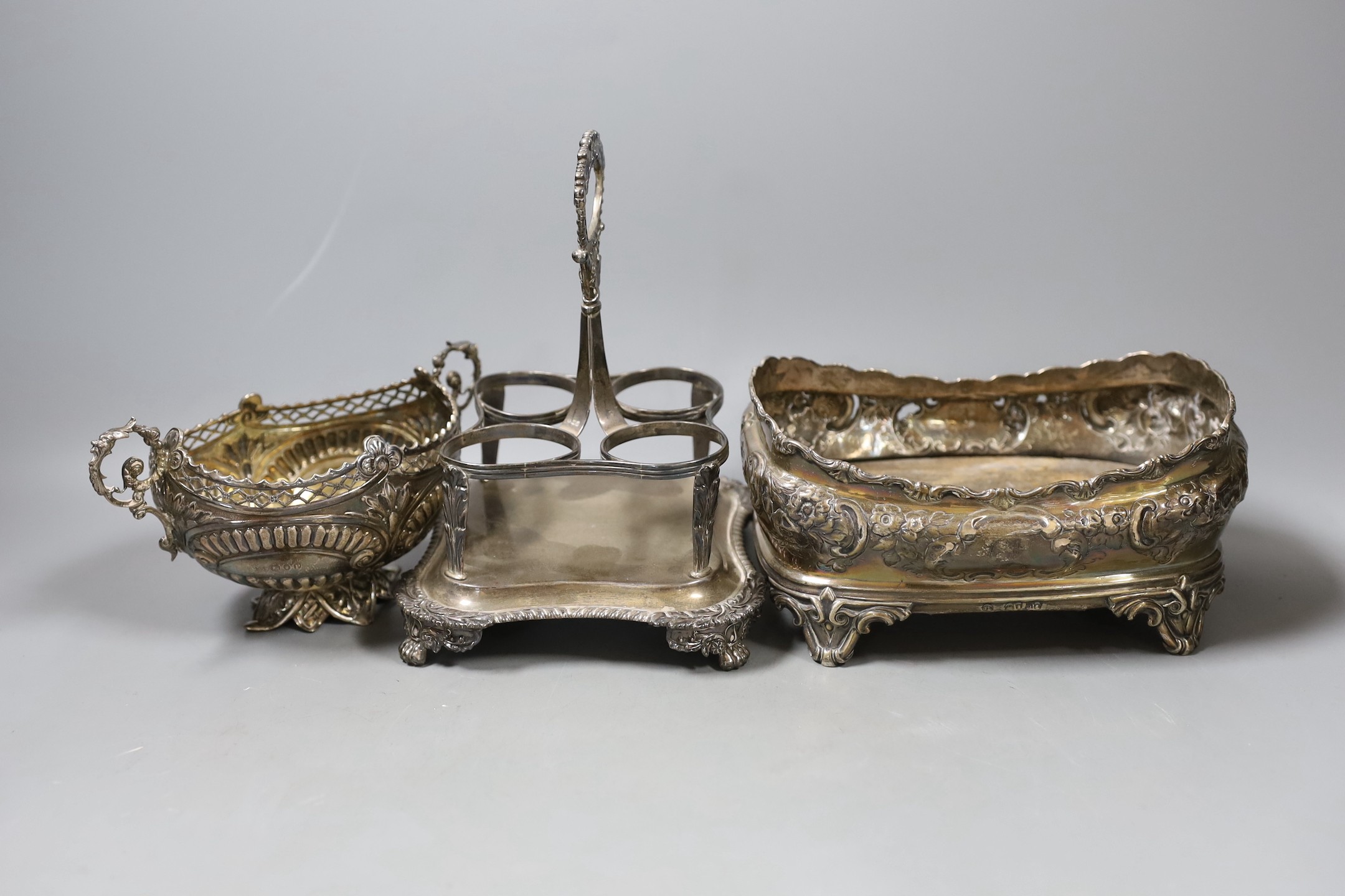A George III silver cruet stand, no bottles, London, 1816, a late Victorian embossed oval silver basket, London, 1890 and an embossed oval silver cruet stand, no handle or bottles.                                        