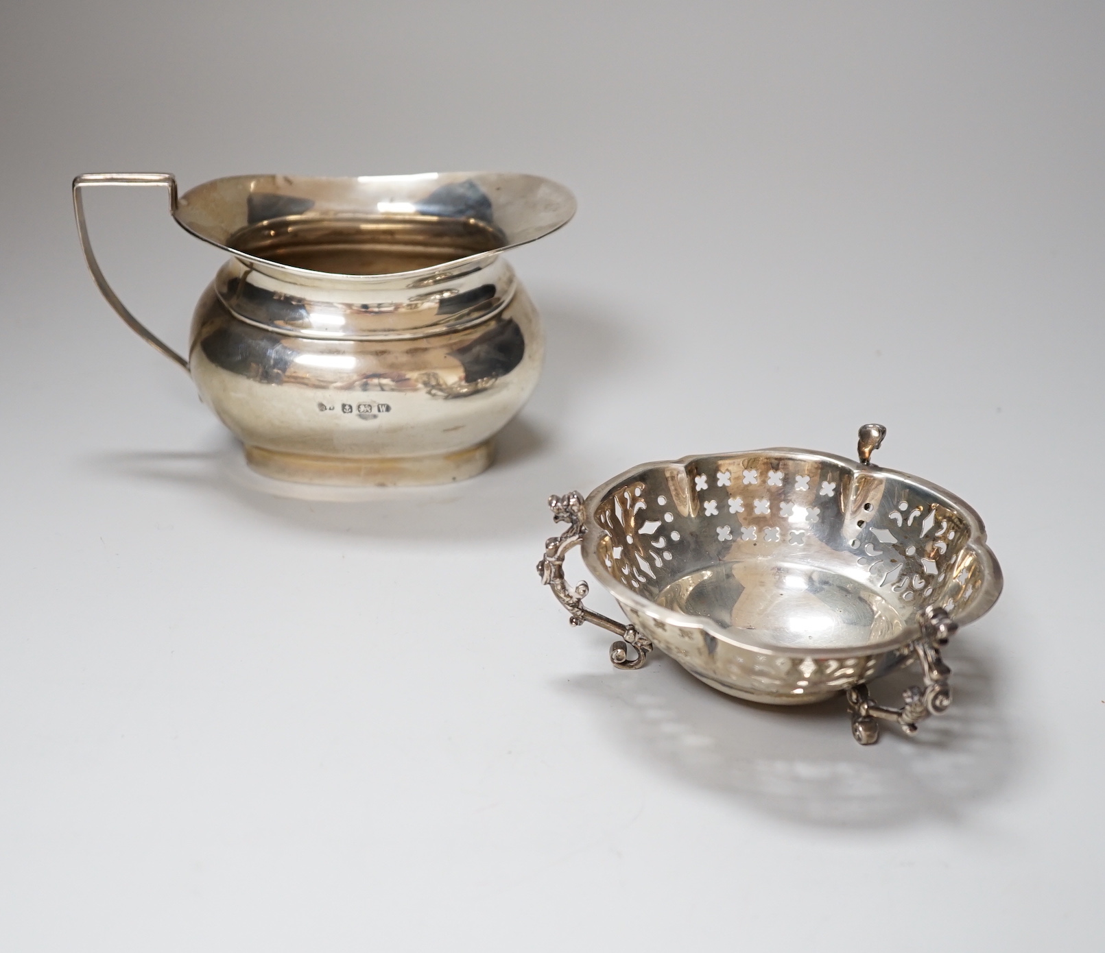 An Edwardian pierced silver bon bon dish, Mappin & Webb, London 1903, 11cm, 153 grams, and a George VI silver cream jug, Birmingham 1946, 98 grams                                                                          