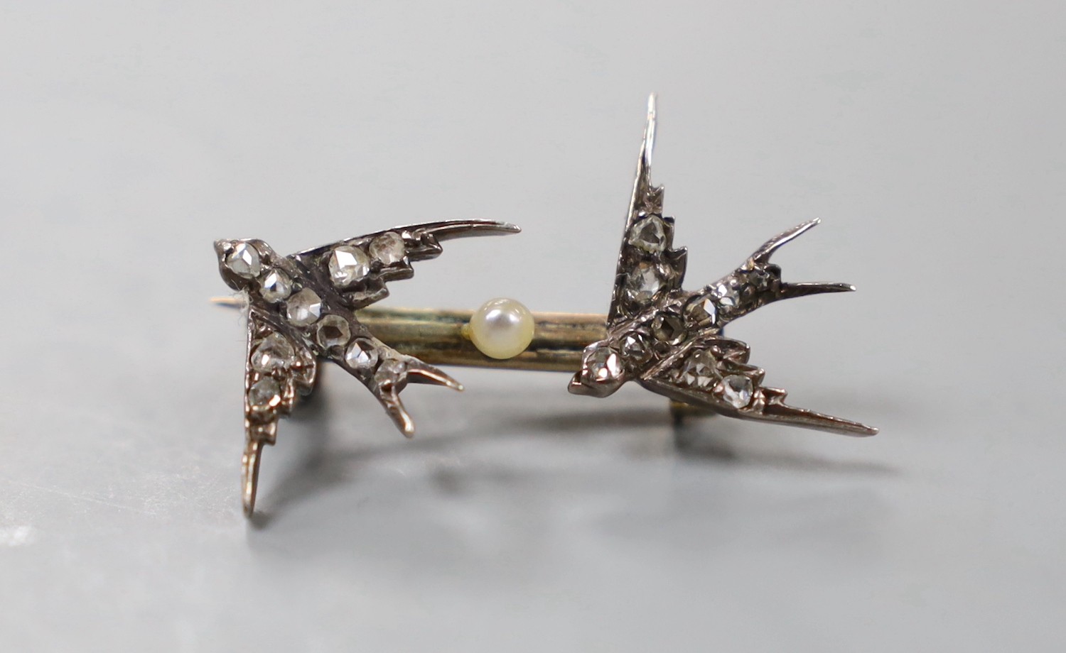 A late Victorian yellow and white metal and rose cut diamond set twin swallow brooch, 27mm, gross weight 2.8 grams.                                                                                                         