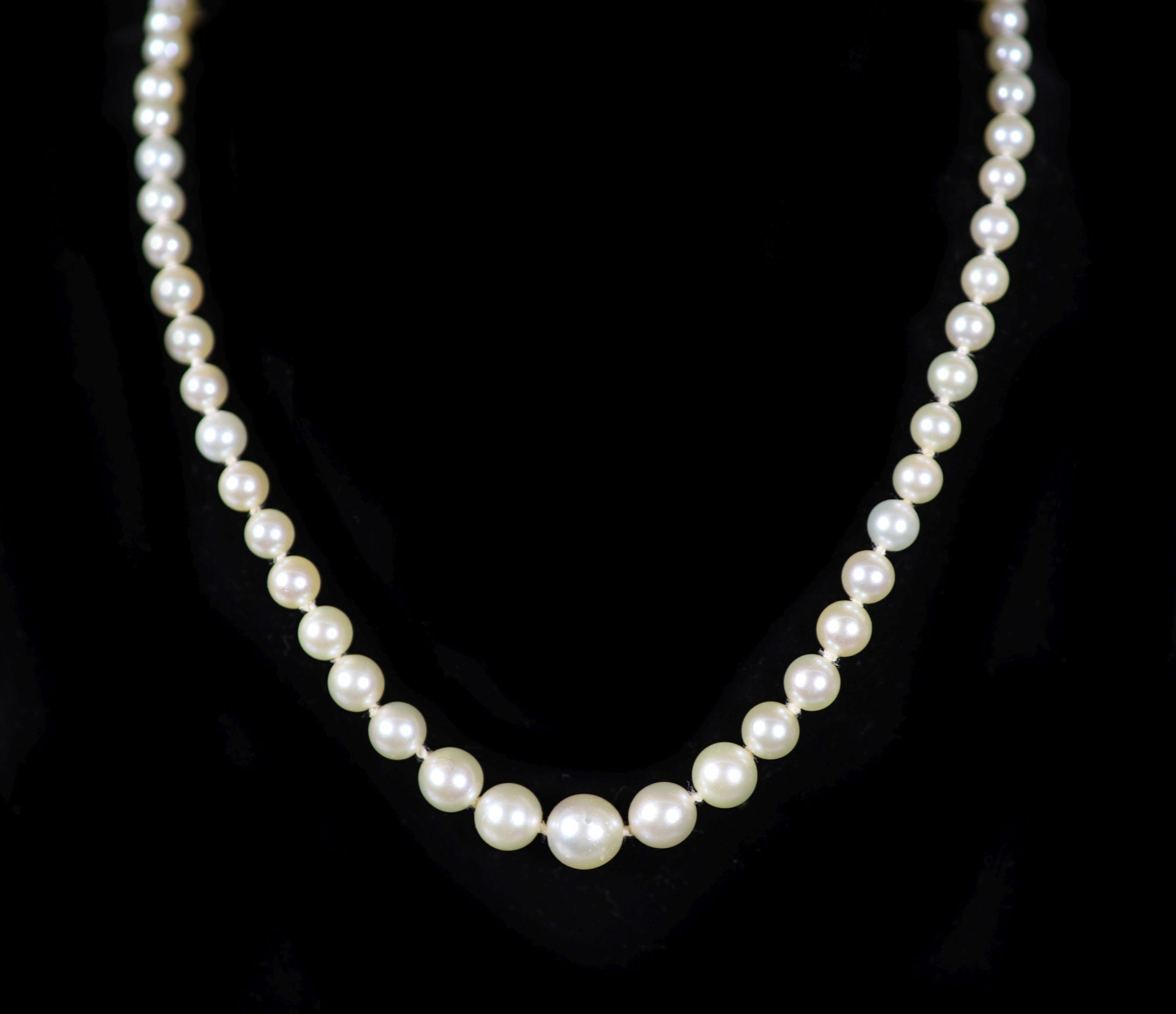 A mid 20th century single strand graduated pearl necklace, with platinum and diamond set open work clasp, signed Cartier with indistinct numbers                                                                            