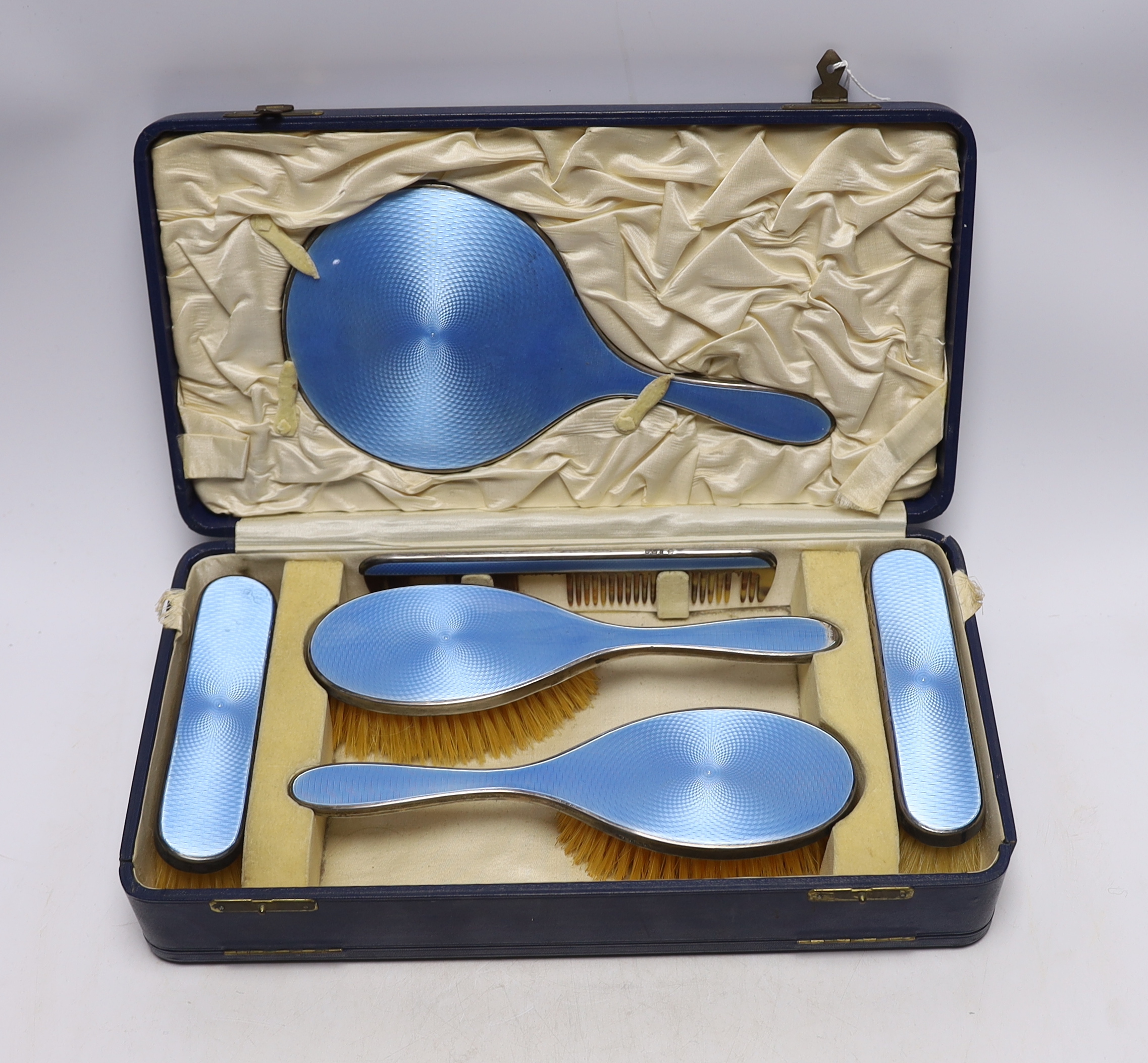 A cased George V silver and blue guilloche enamel mounted six piece mirror and brush set, Charles Henry Dumenil, London, 1932.                                                                                              