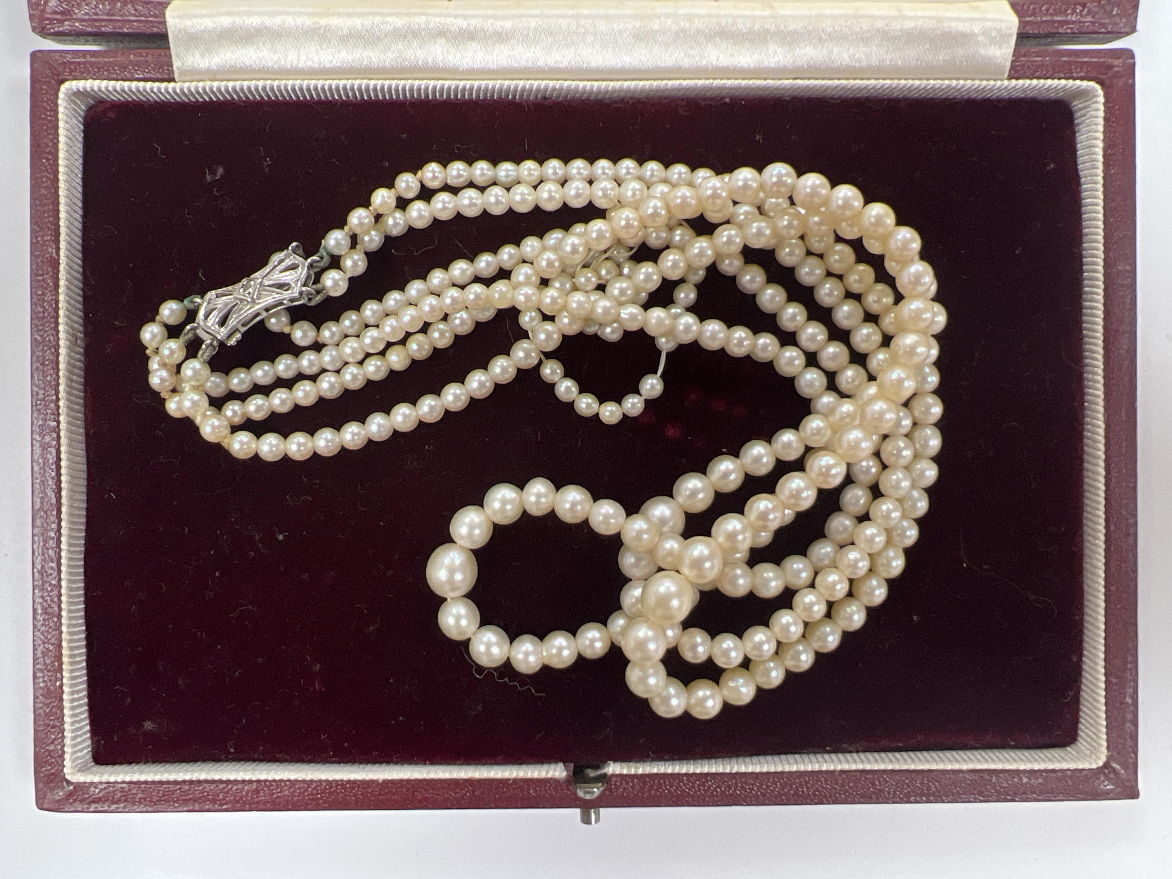 A triple strand graduated cultured pearl choker necklace, with diamond chip set 9ct white gold clasp, 38cm, in a Harrods box, together with some loose beads.                                                               