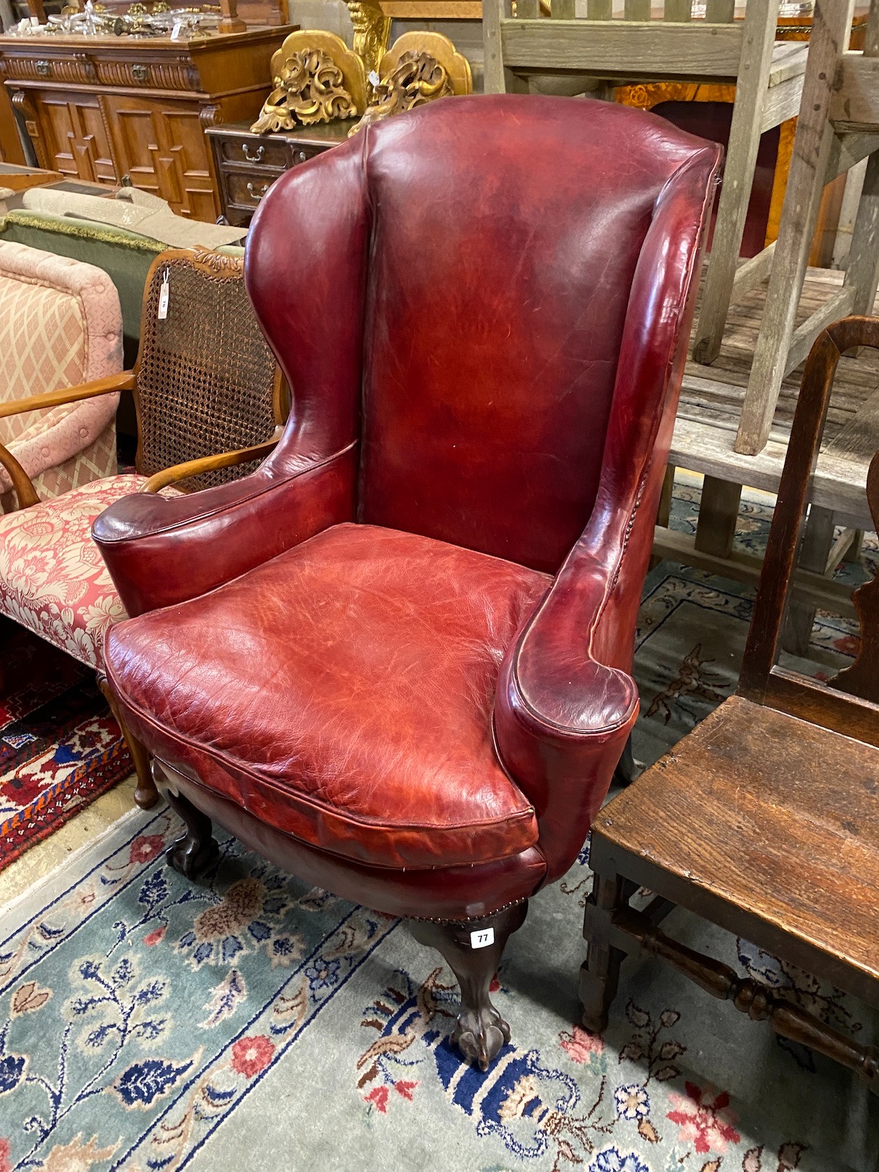 A George III style mahogany red leather upholstered wing armchair, width 91cm, depth 60cm, height 116cm                                                                                                                     