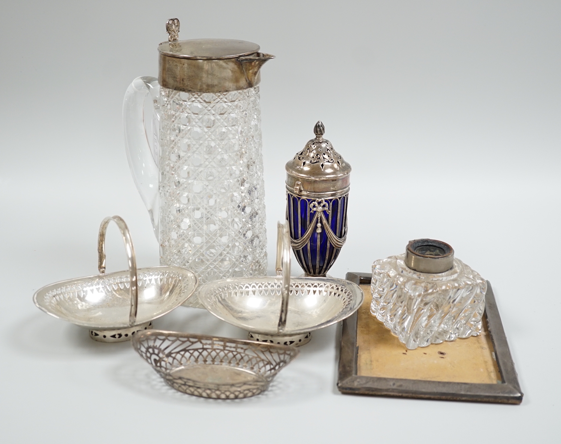 Sundry silver items including a Victorian silver mounted glass lemonade jug (a.f.), mounted glass sugar caster, damaged inkwell, photograph frame, pair of silver bonbon baskets and a small silver dish.                   